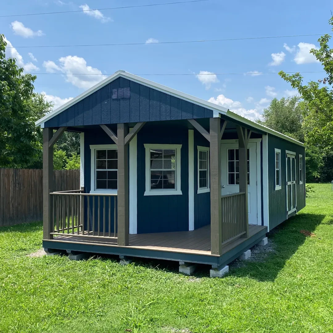 A large dark blue building with a L-shaped porch and multiple doors and windows