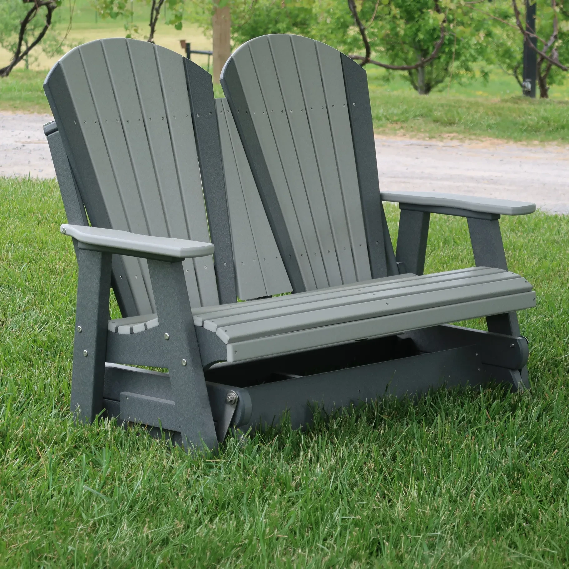 a piece of polywood outdoor patio furniture sitting in a grassy yard