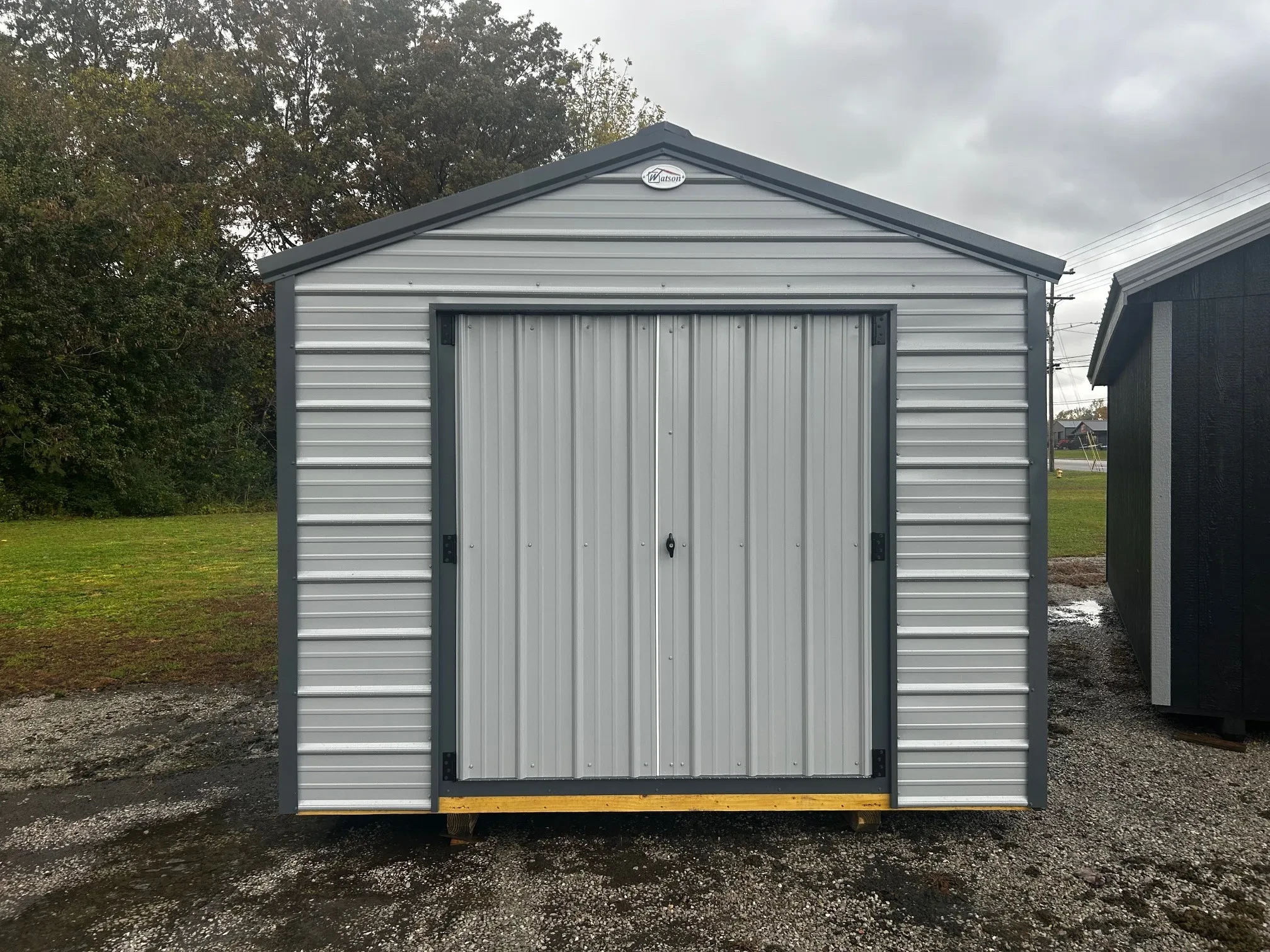 The front of a light gray metal shed