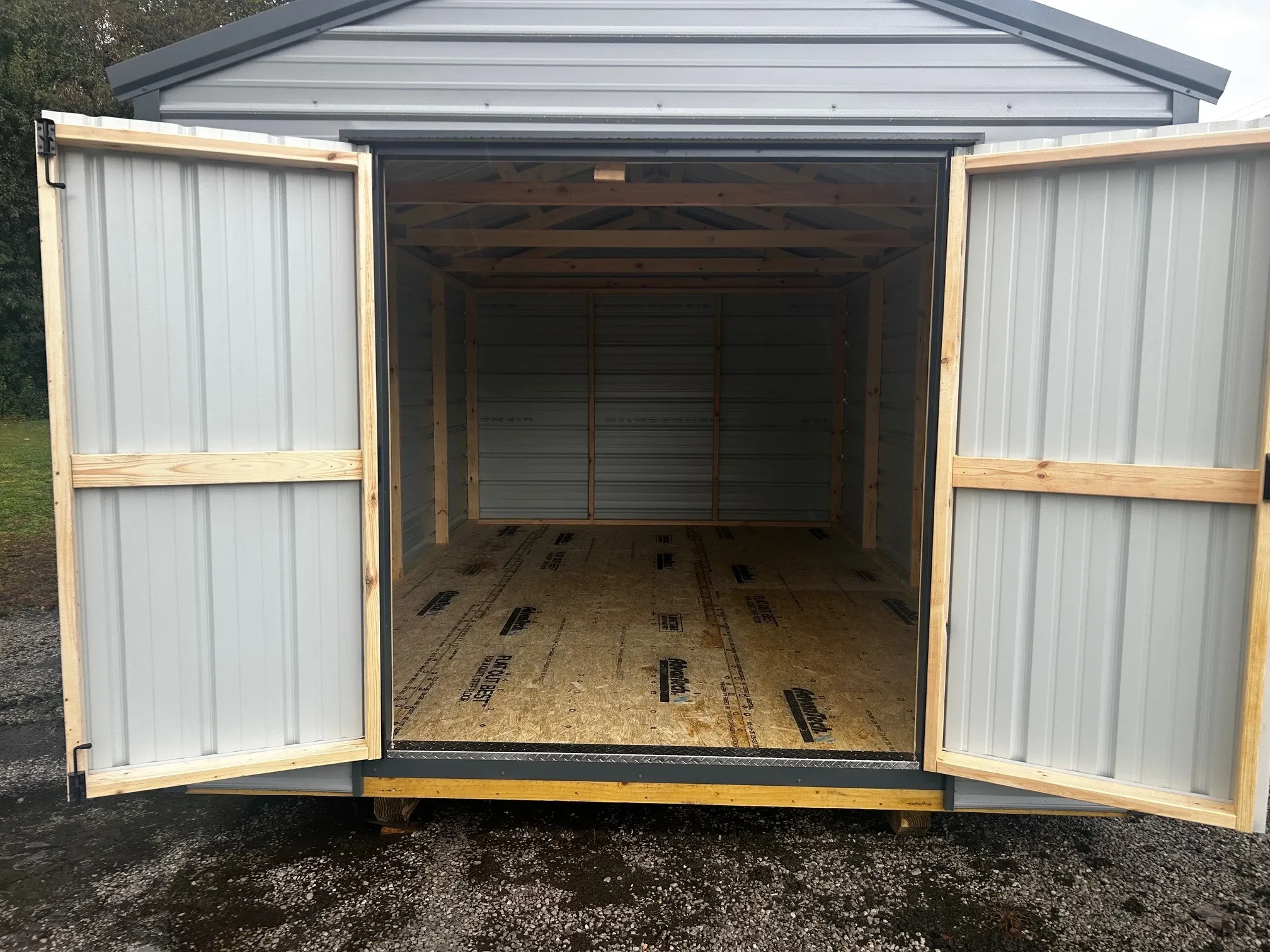 The inside of a gray metal shed with the double doors wide open