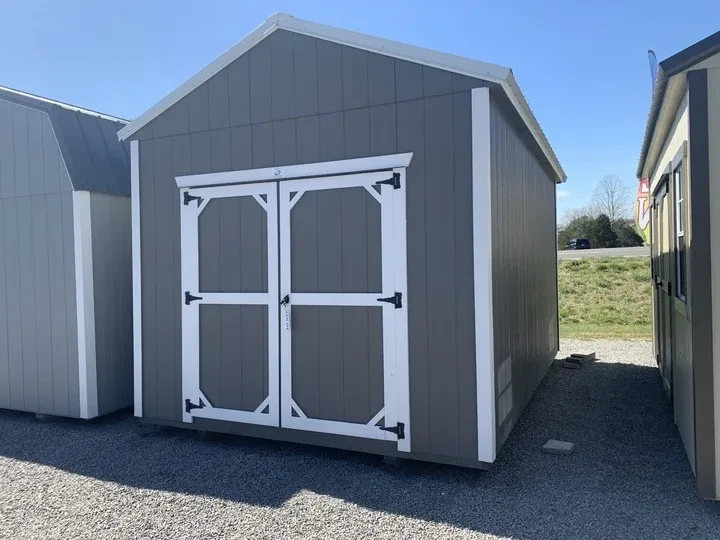 a gray wood shed with white trim