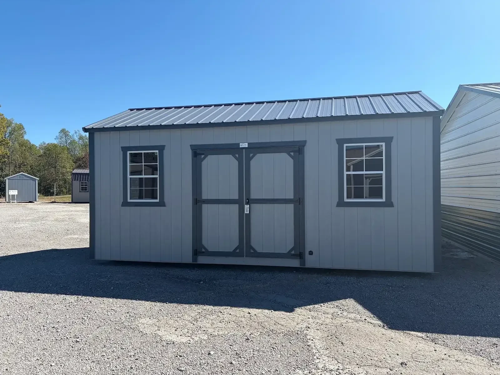 exterior view light gray siding, slate gray roof & trim double doors, windows