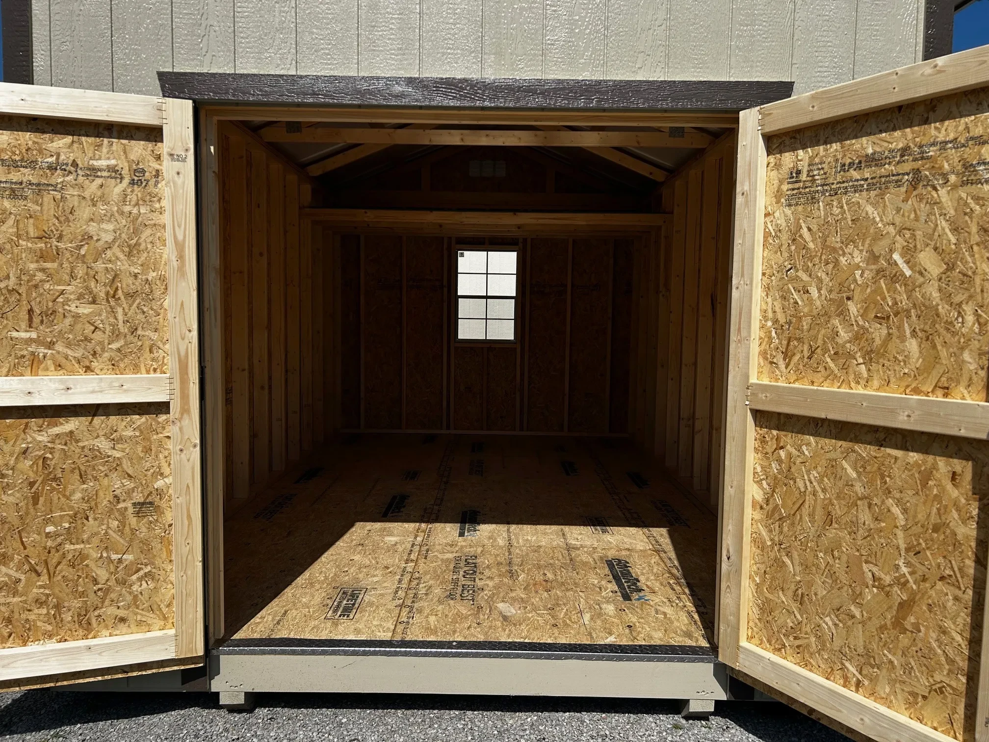 The inside of a shed through the open double doors showing the inside with a window