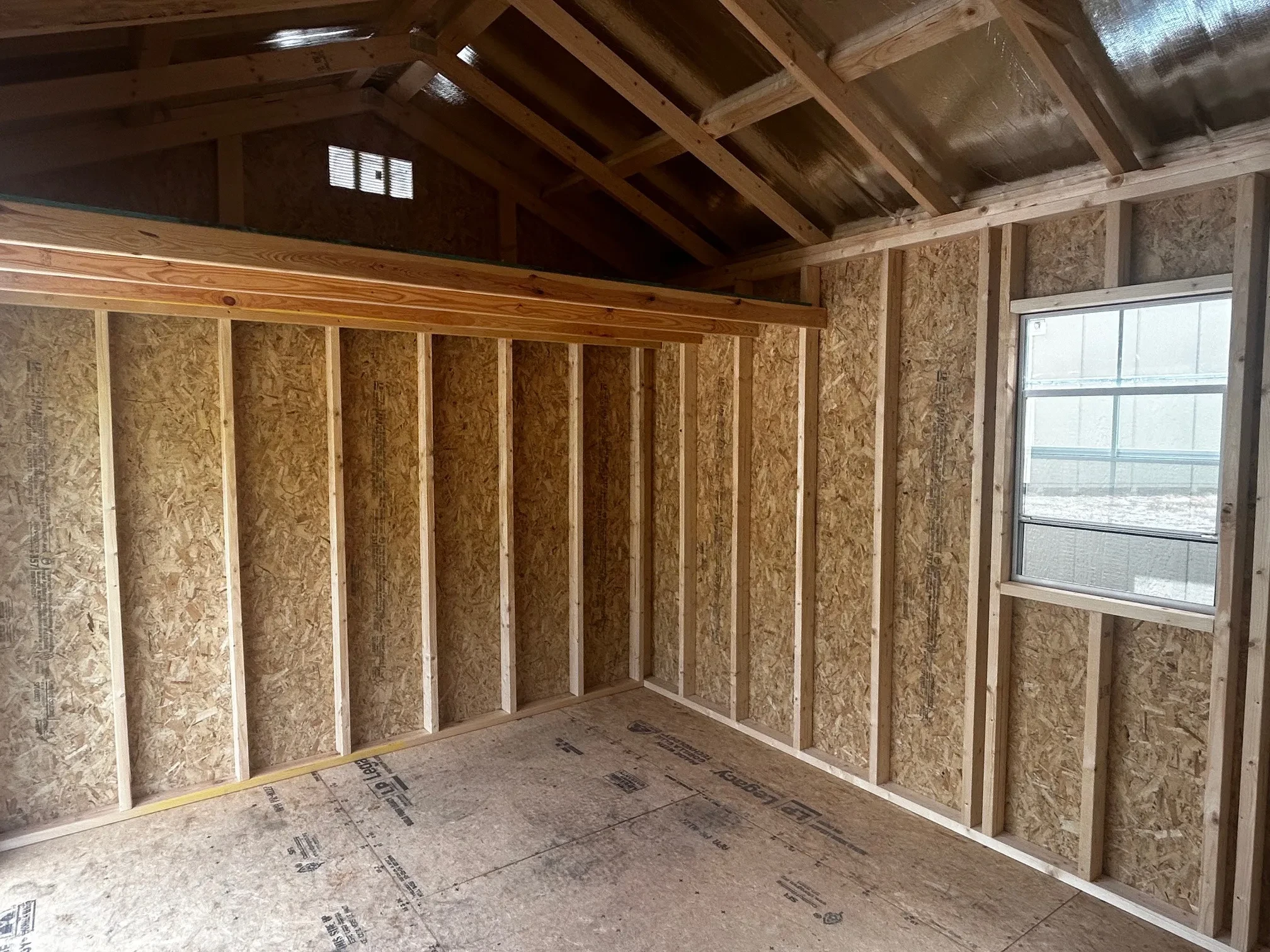The inside of a shed with a loft and a window