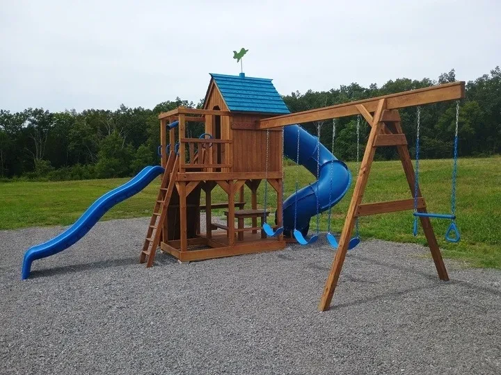 a pretty wood and blue playset with multiple swings and slides