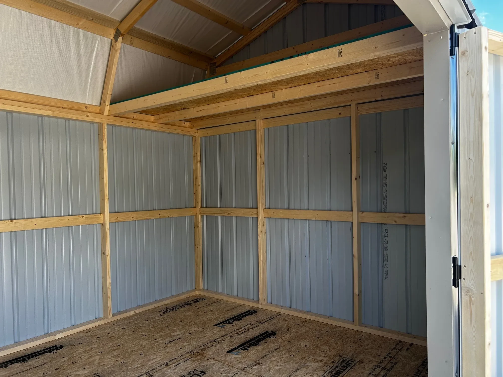 the inside of a metal lofted barn showing the loft