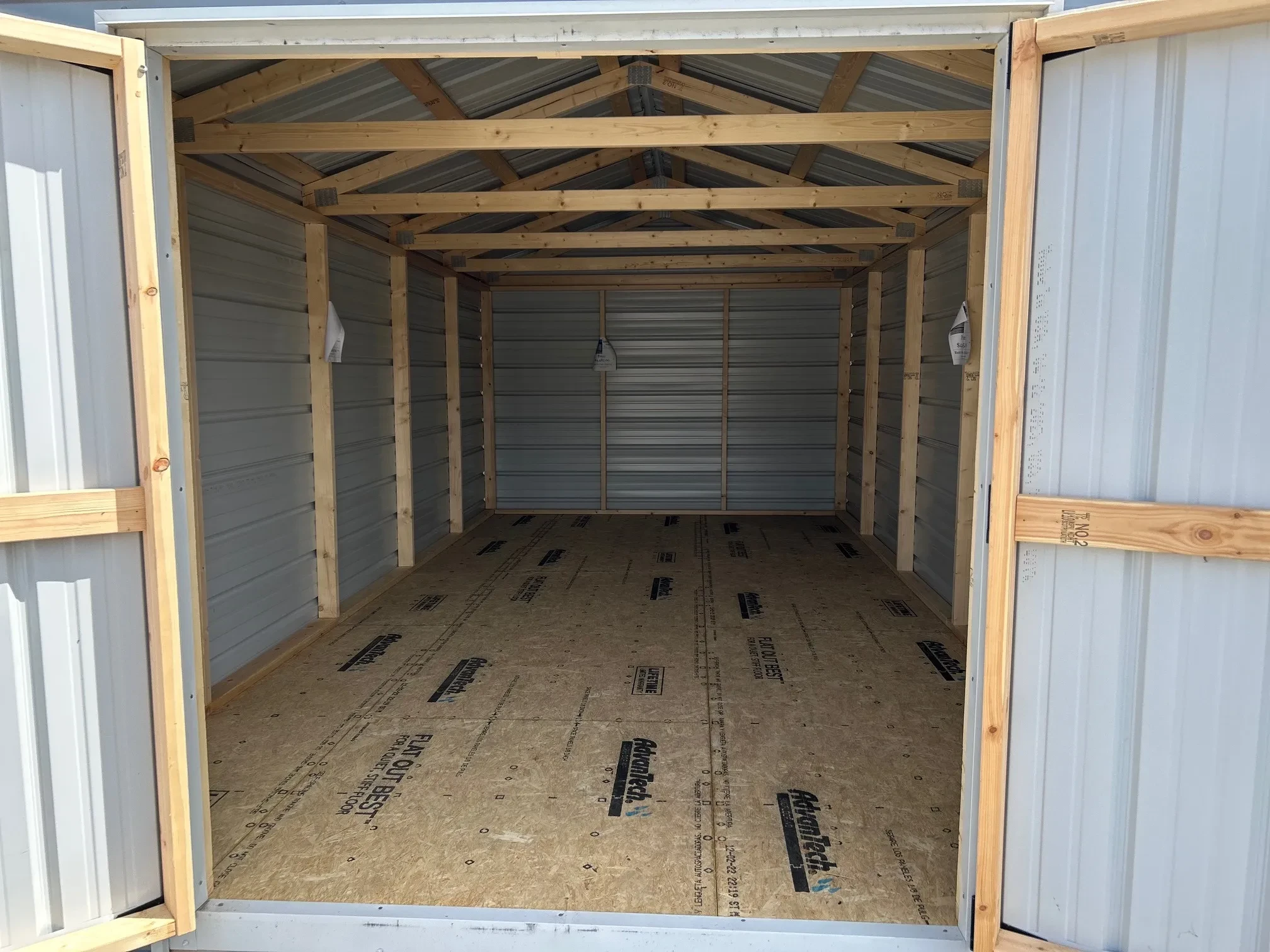 The inside of a metal shed through the open double doors