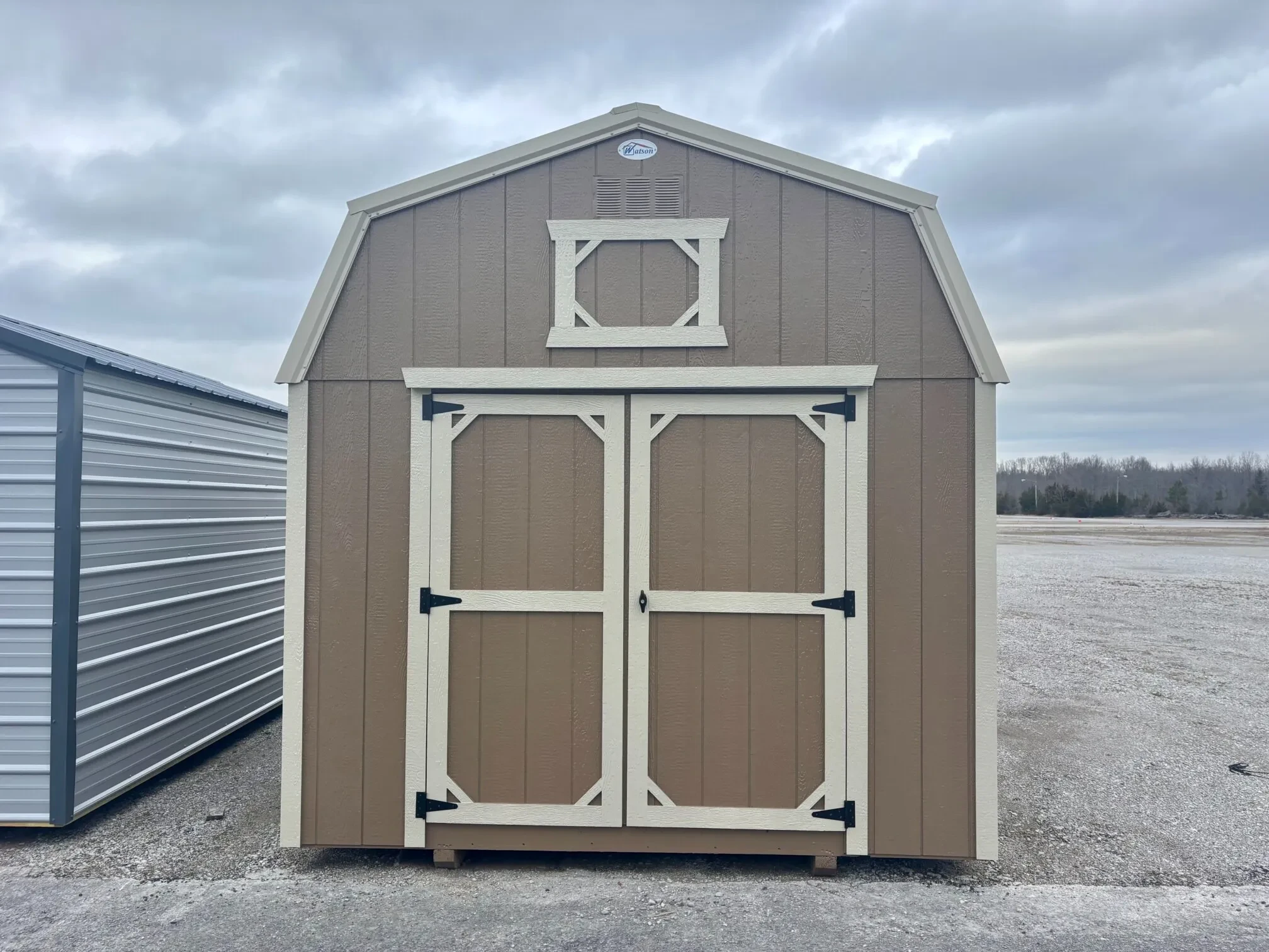 the front of a lofted barn painted a stone color