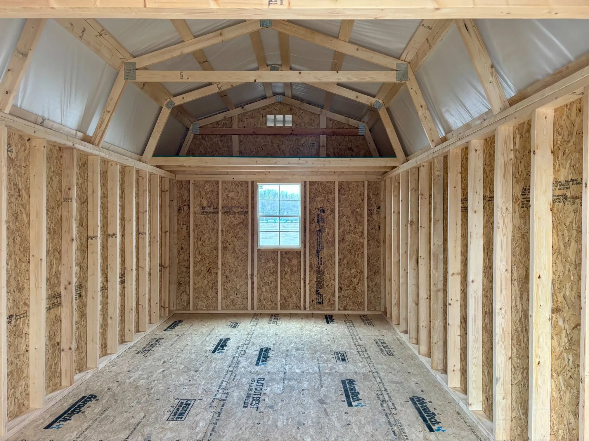 the inside of a lofted barn with a loft and a window on the back wall