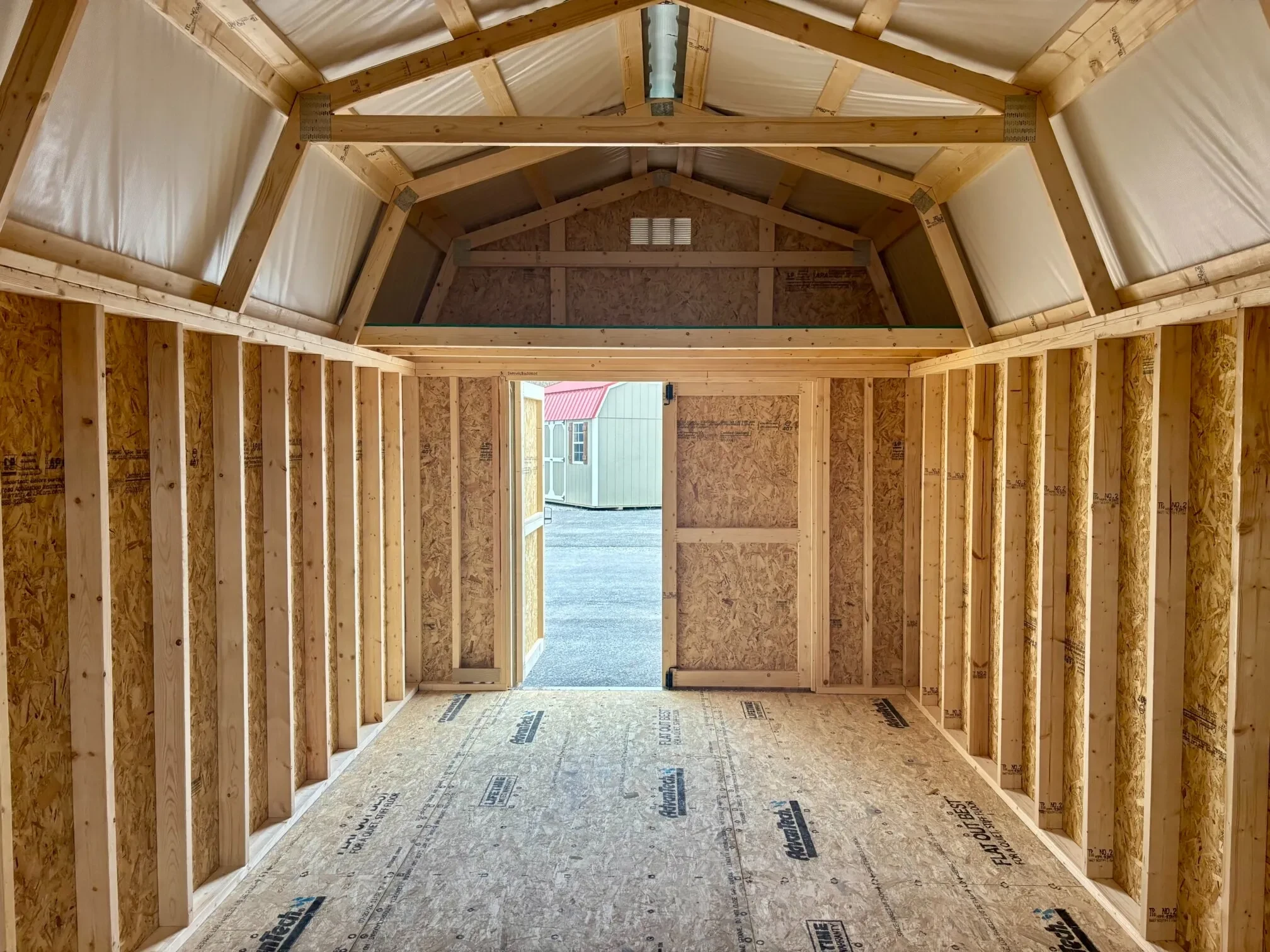 the inside of a lofted barn showing one of the double doors open