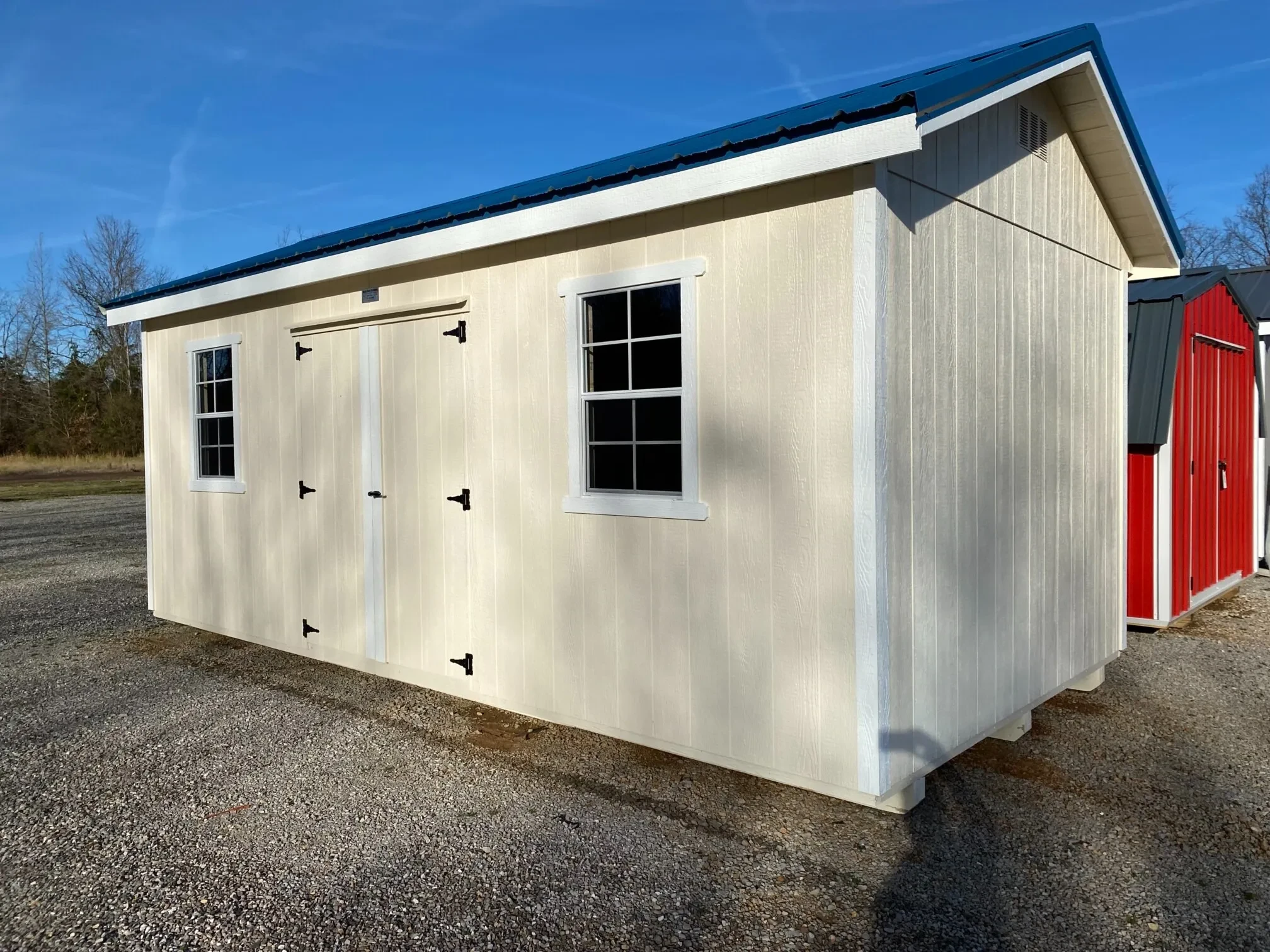a navajo white colored wood garden shed with double doors and two windows