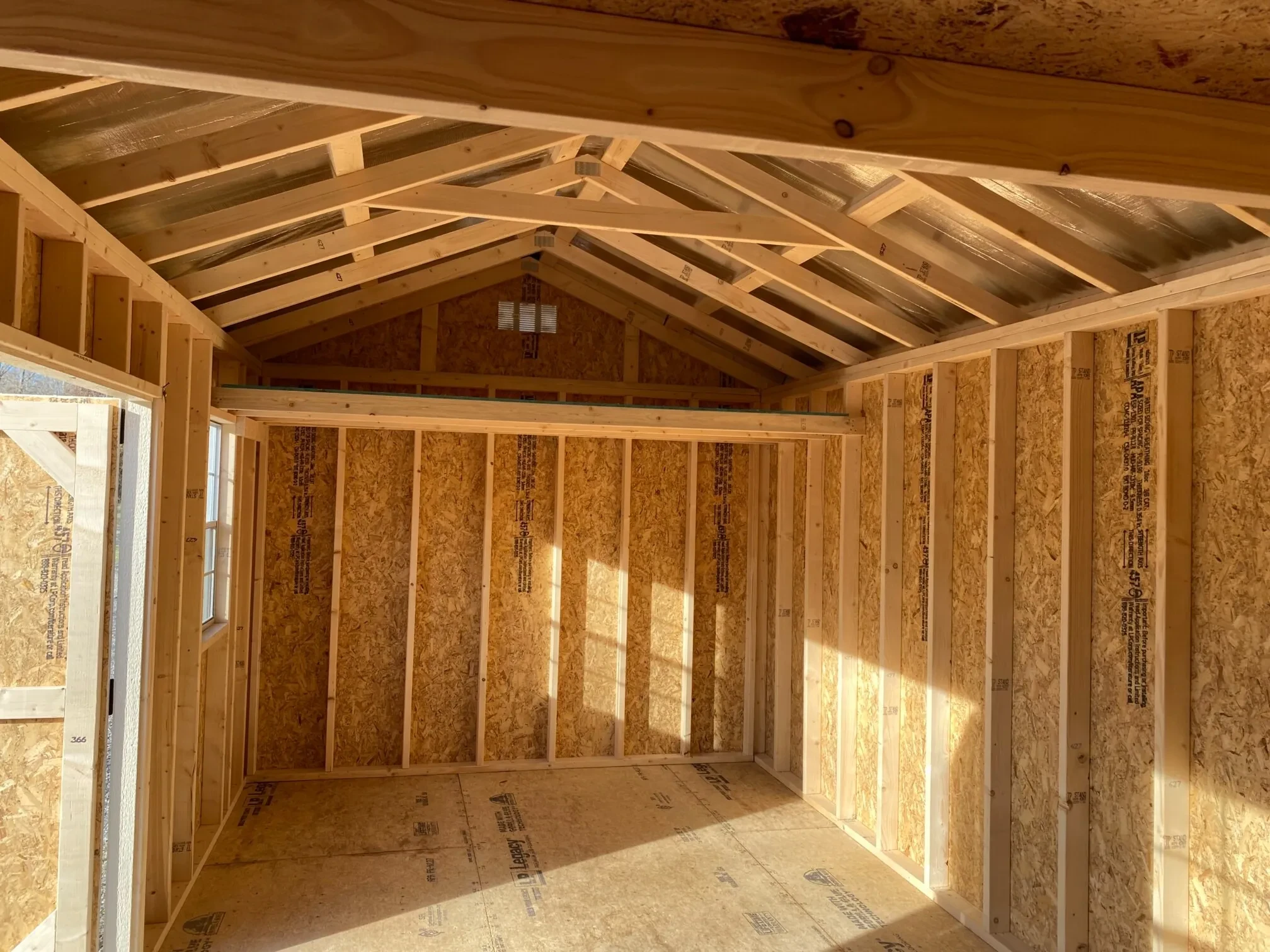 a loft inside a wood garden shed with double doors open