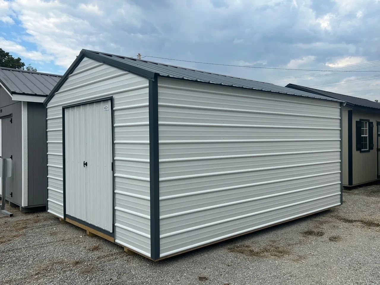 the front corner view of a 12x16 metal shed painted white with gray trim