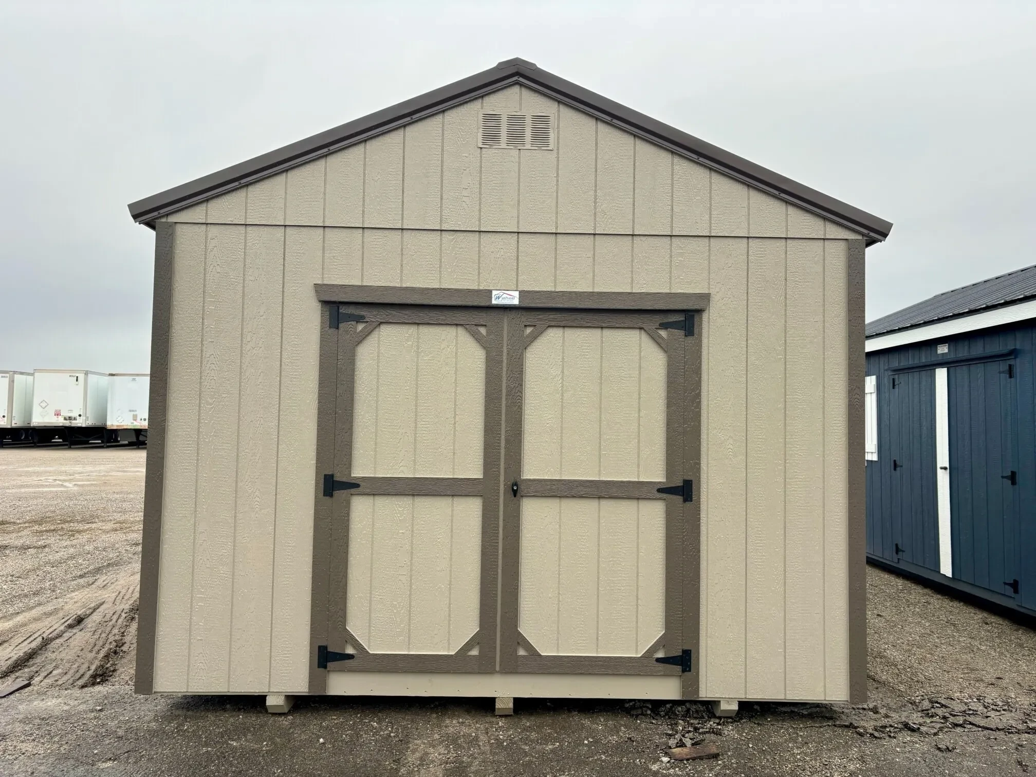 a 12' wide wood shed with double doors painted clay
