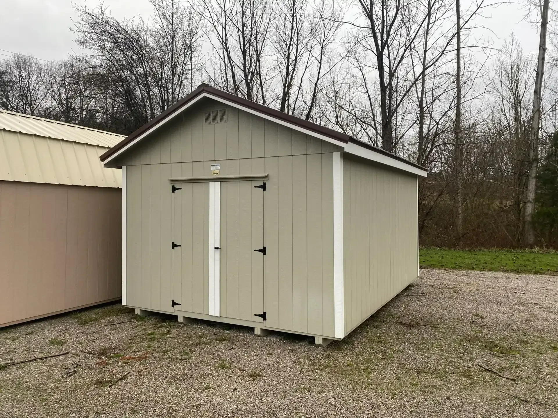A wood shed painted clay with white trim and double doors