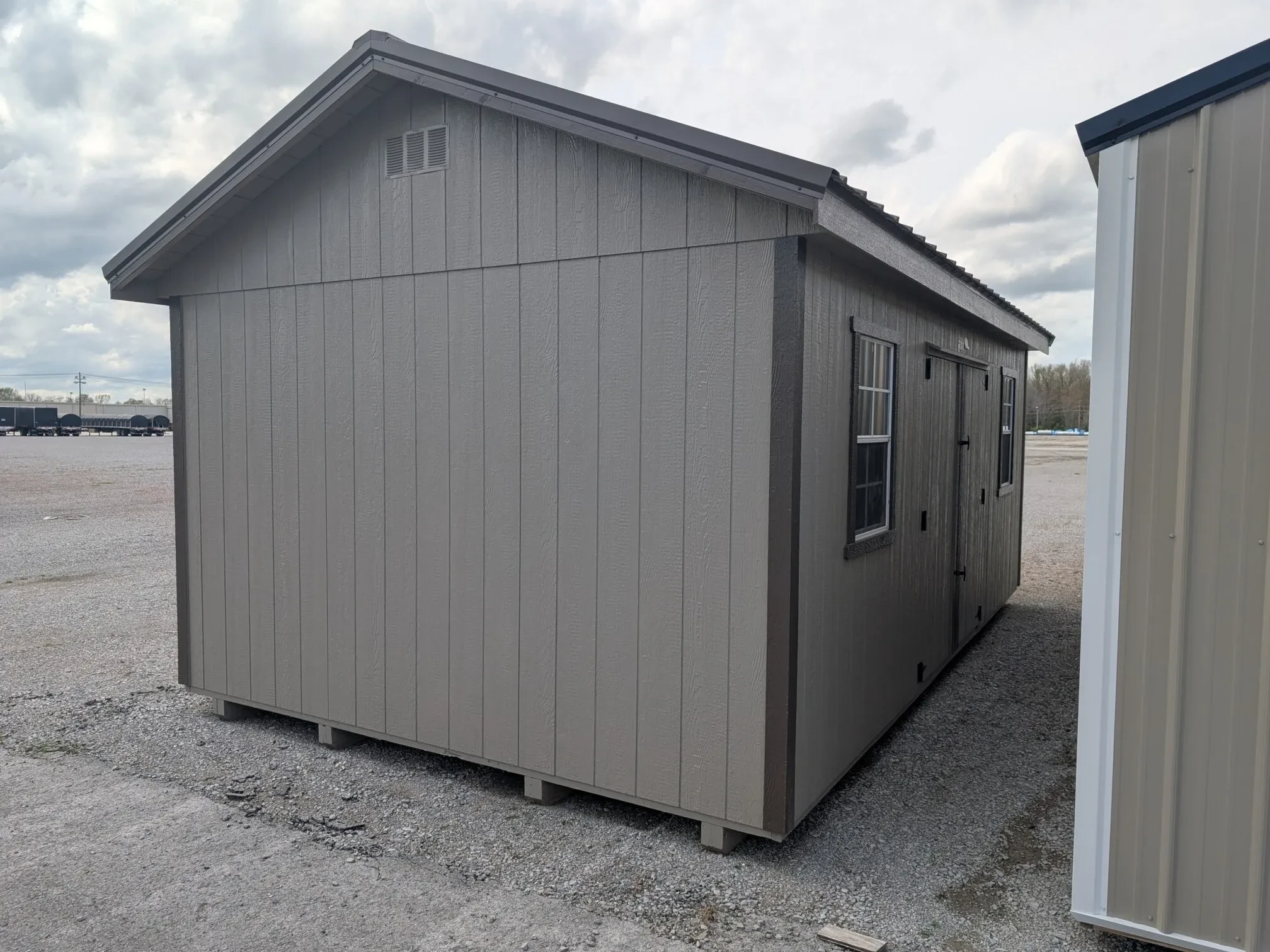 the side of a premium garden shed showing a vent and double doors and two windows