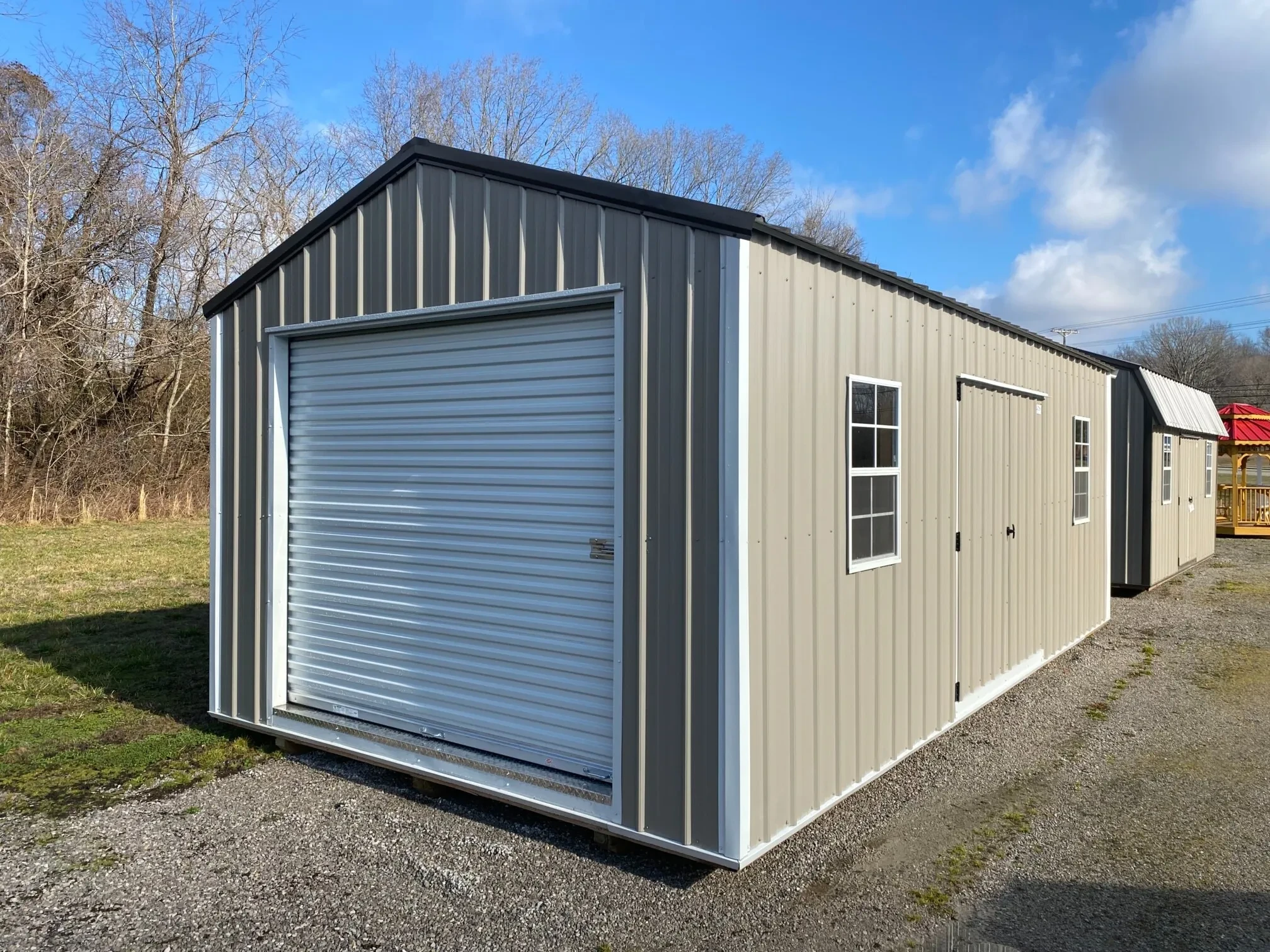 A metal garage shed with a rollup garage door and 2 windows and double doors