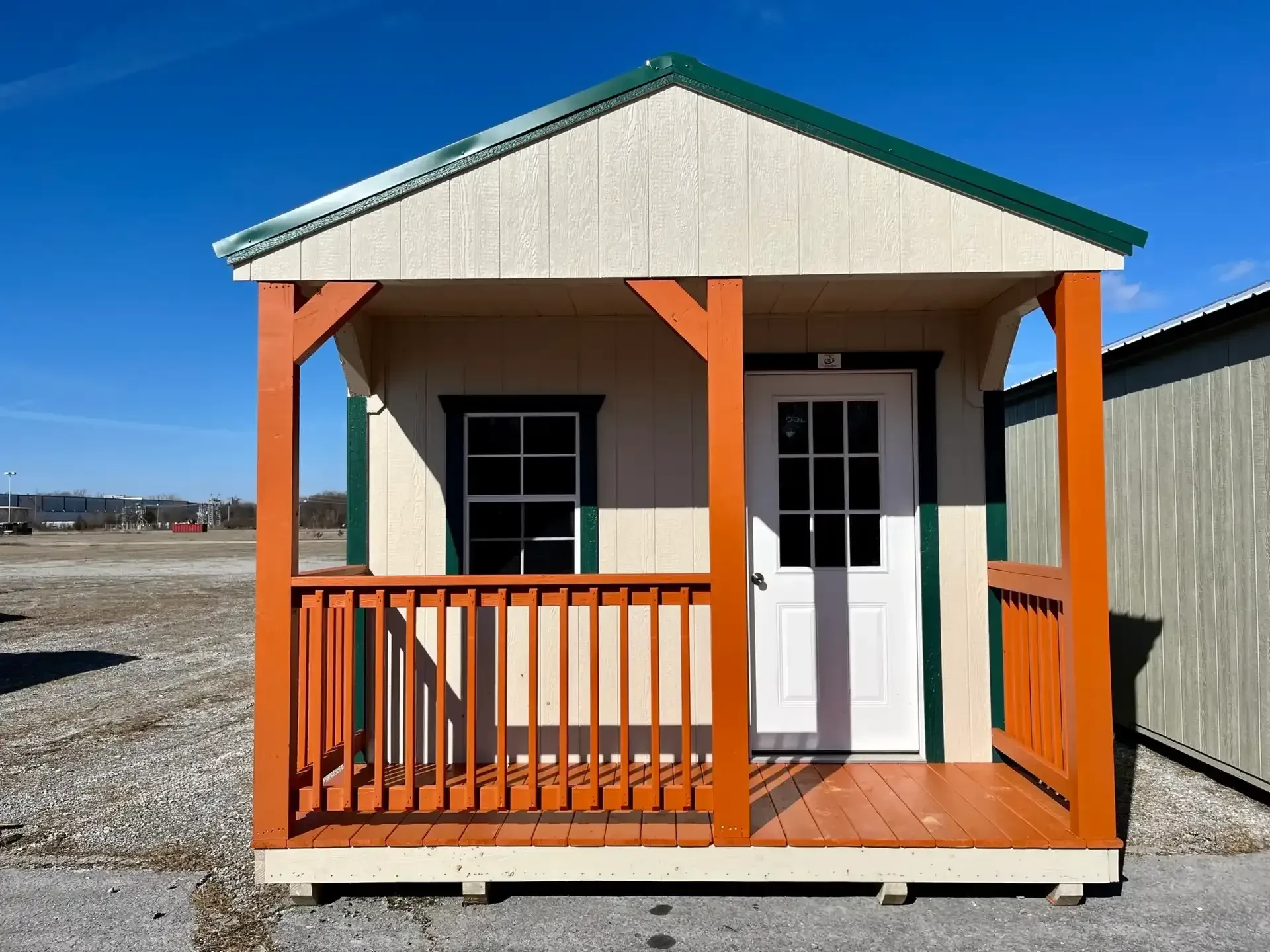 the front of a wood cabin with an orange porch