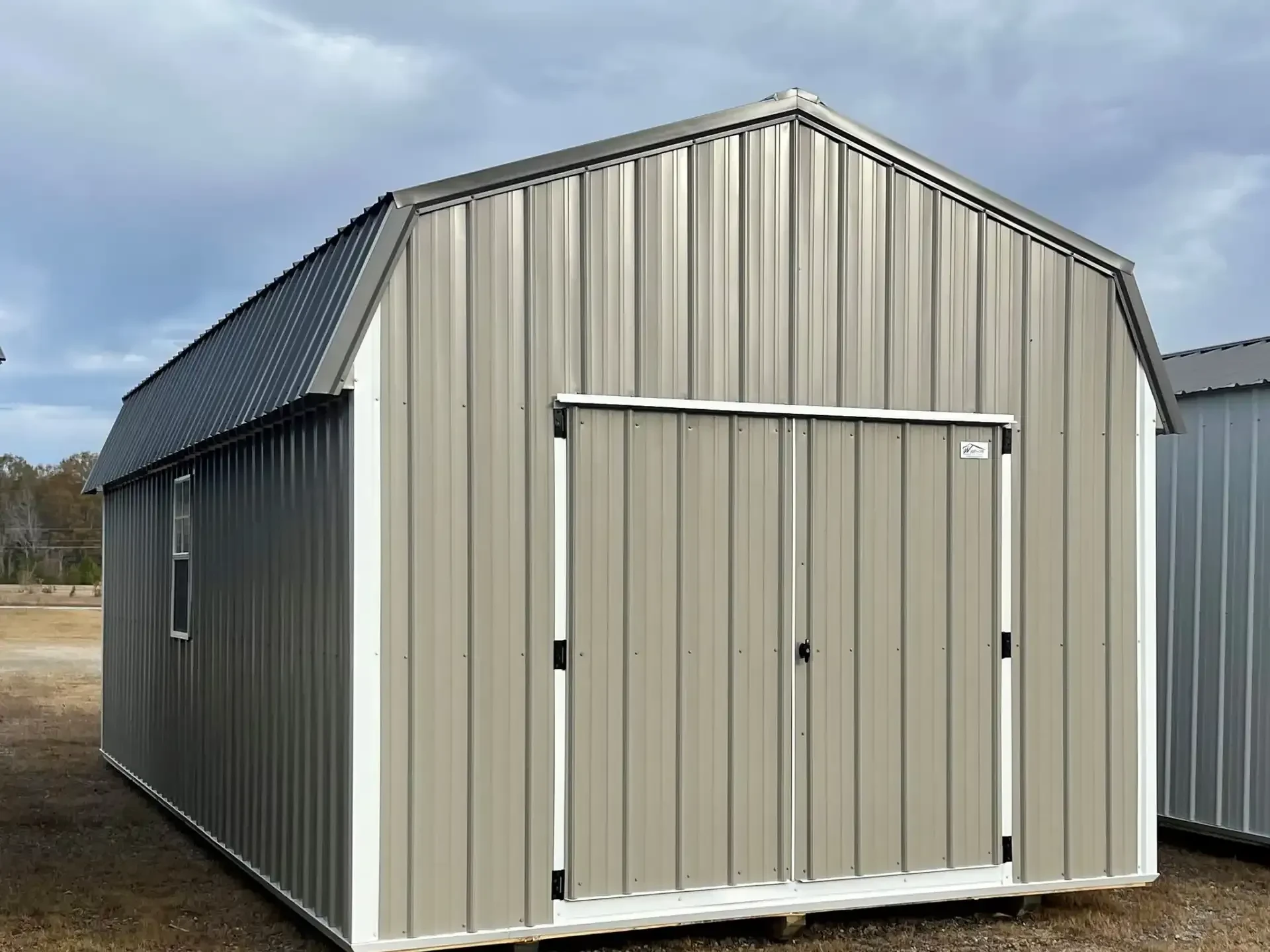 a large metal lofted barn with double doors painted a clay colored