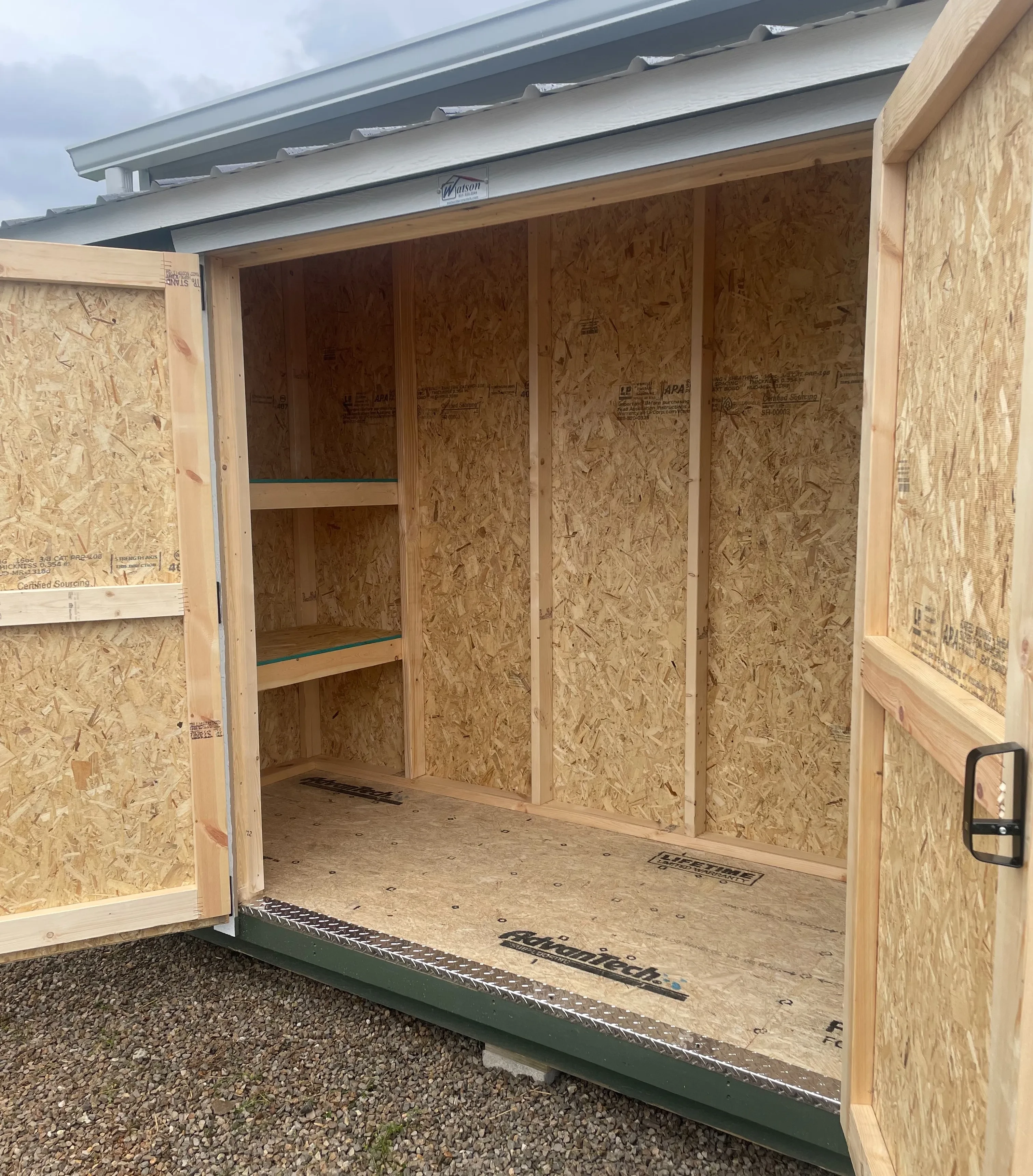 Shelves inside little leanto shed.