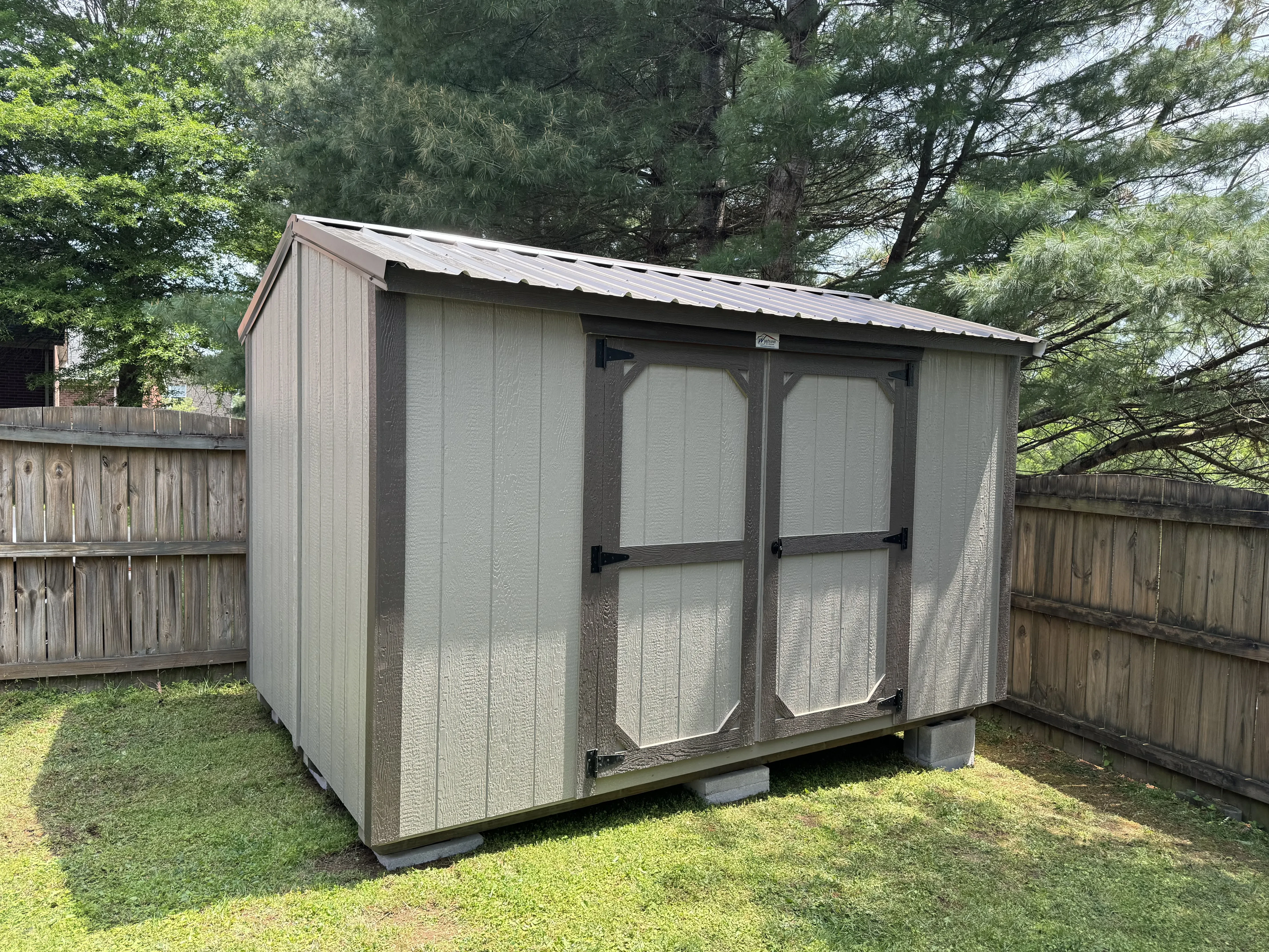 Split-shed set up in the corner of a small yard.