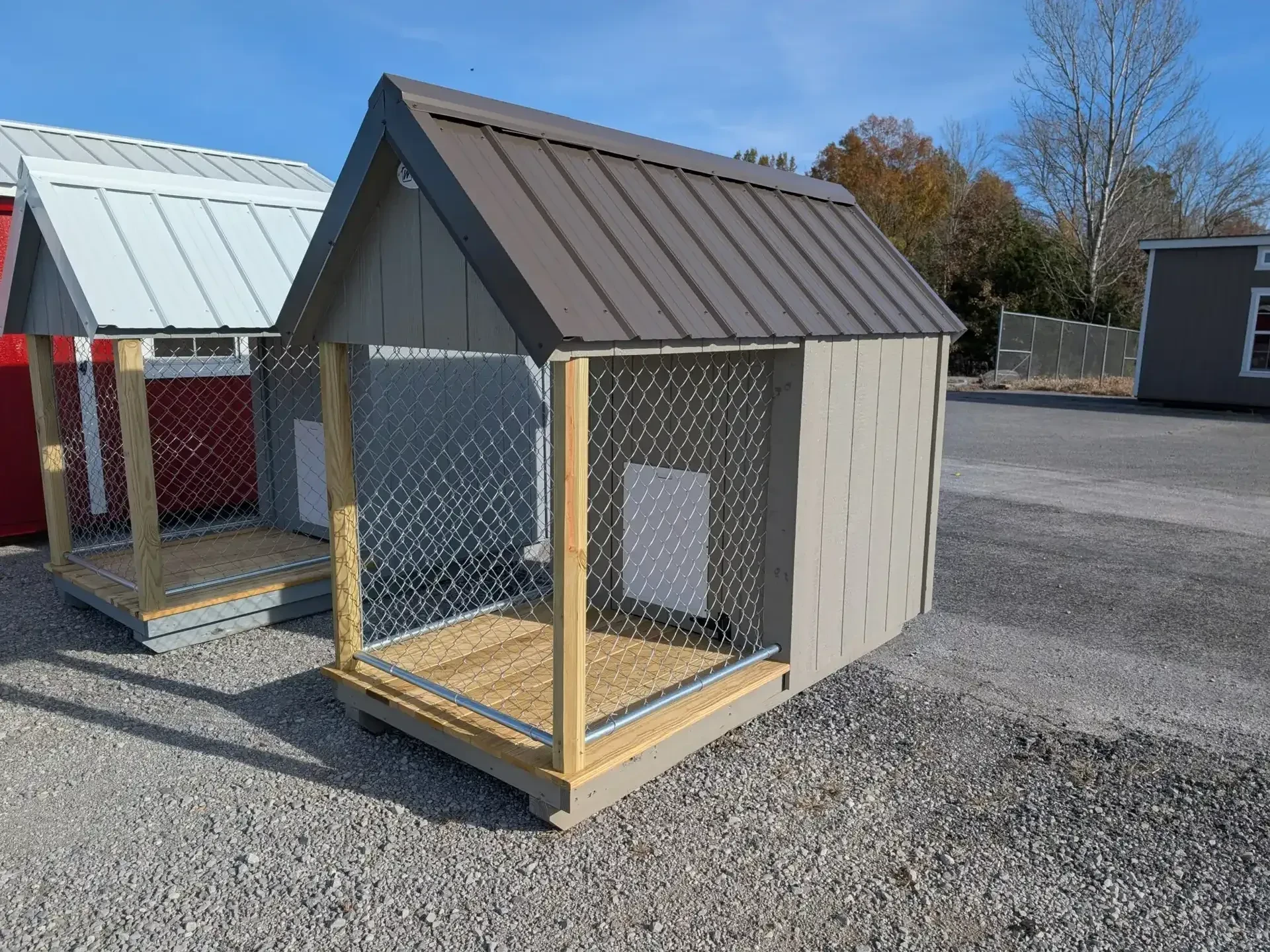 a gray dog kennel with a chain link fenced in run