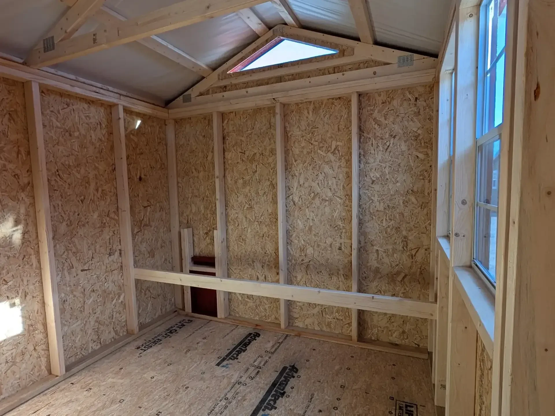 the inside of a chicken coop with a roosting bar