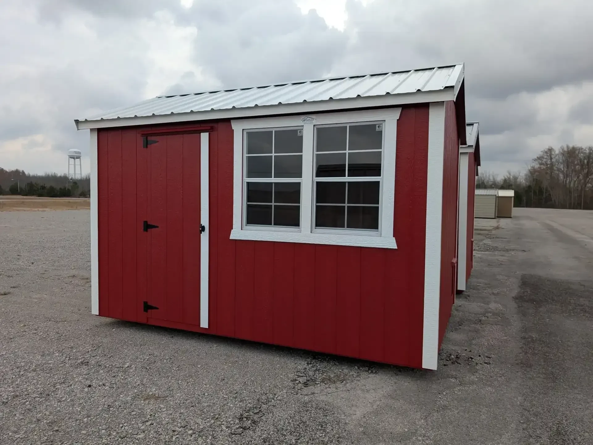 a red chicken coop with two windows next to each other and white trim