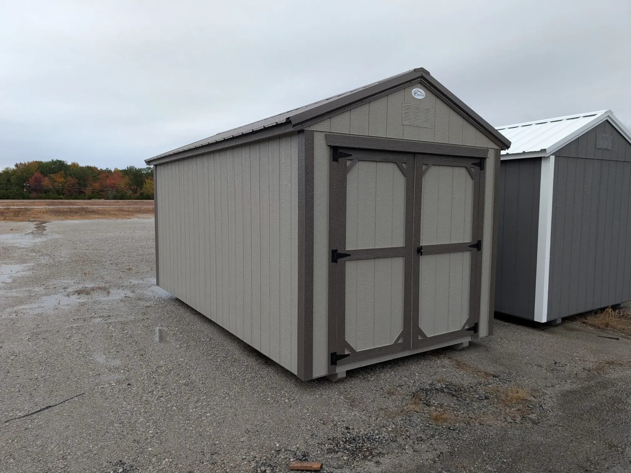 a wood shed painted clay with bronze trim and double doors