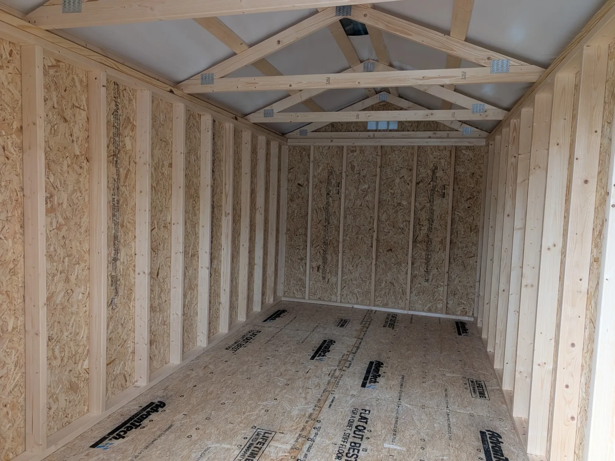 inside a wood shed showing the floor and framing