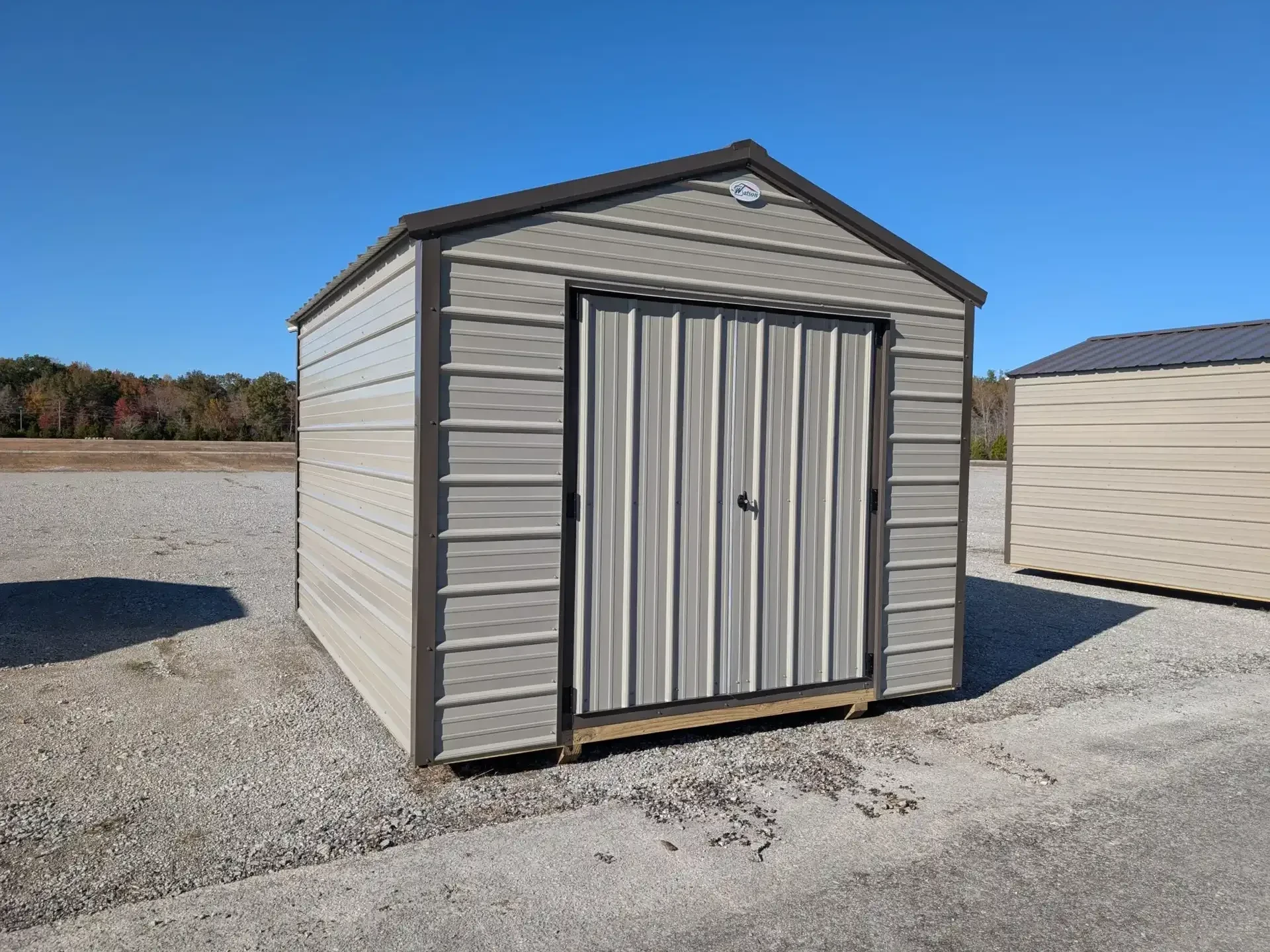 a metal shed painted clay with double doors