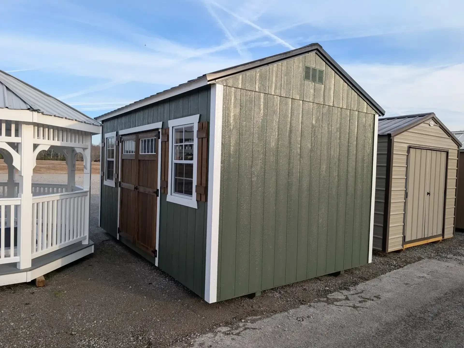 a green garden shed with stained doors and two windows