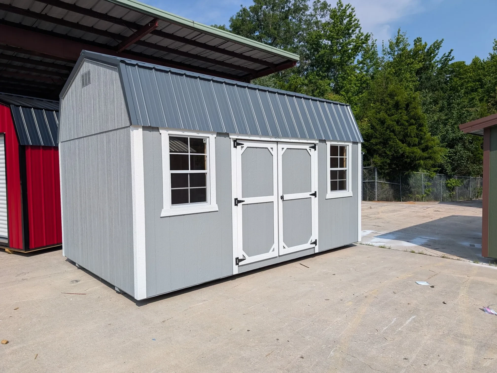 a side lofted barn with two windows and double doors