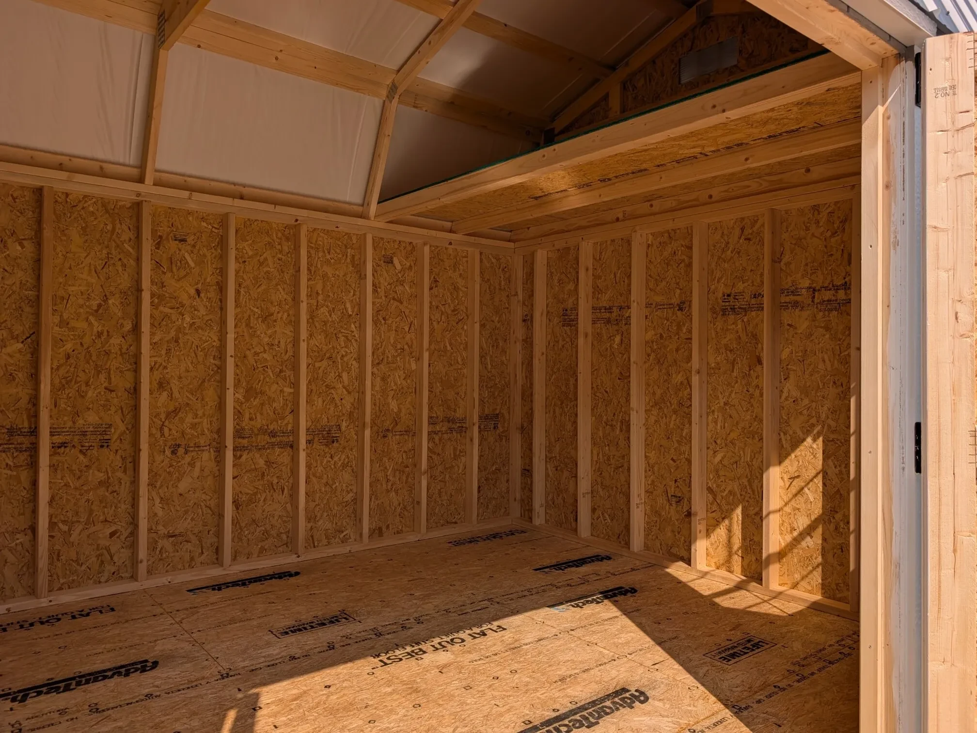 inside a lofted barn showing a loft and the double doors open