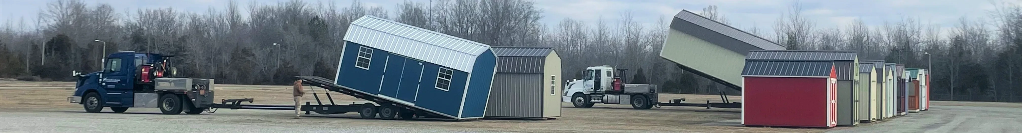 Two trucks loading up sheds from a row