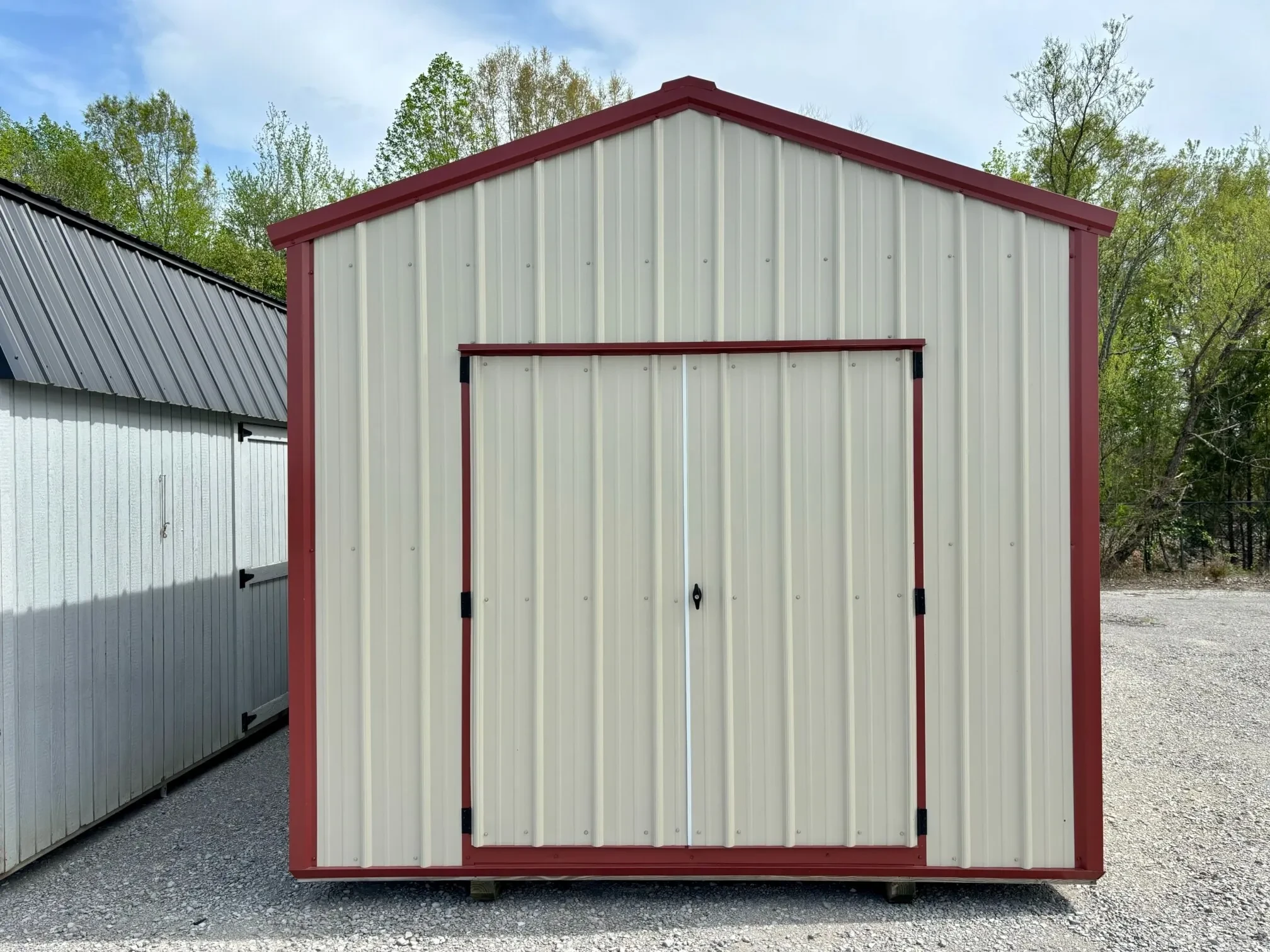 a metal shed with red trim and double doors