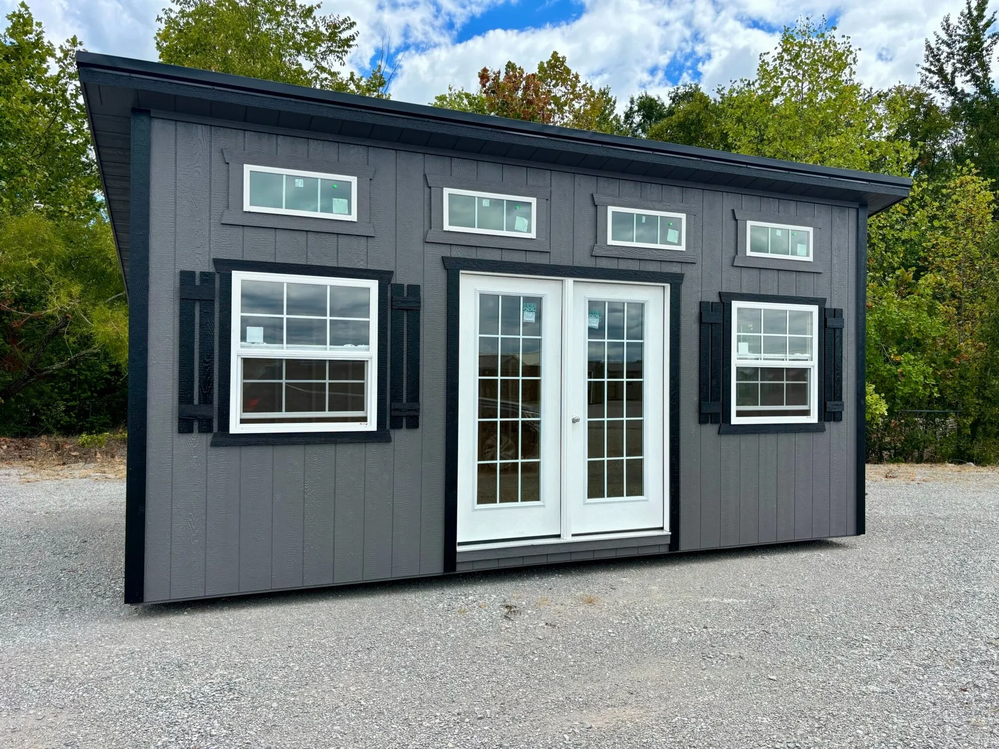 a studio shed with transom windows and vinyl insulated windows and French doors