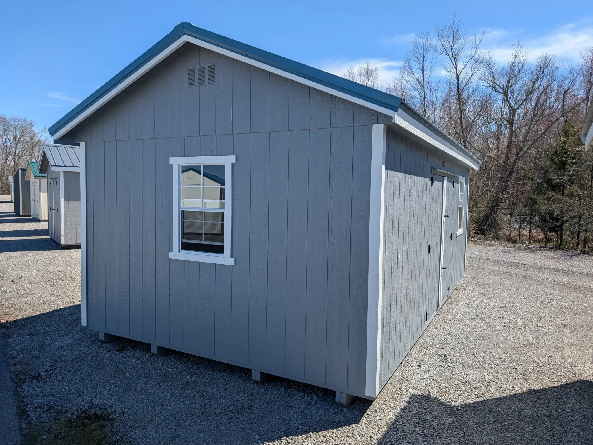 the side of a blue shed with a 2x3 window