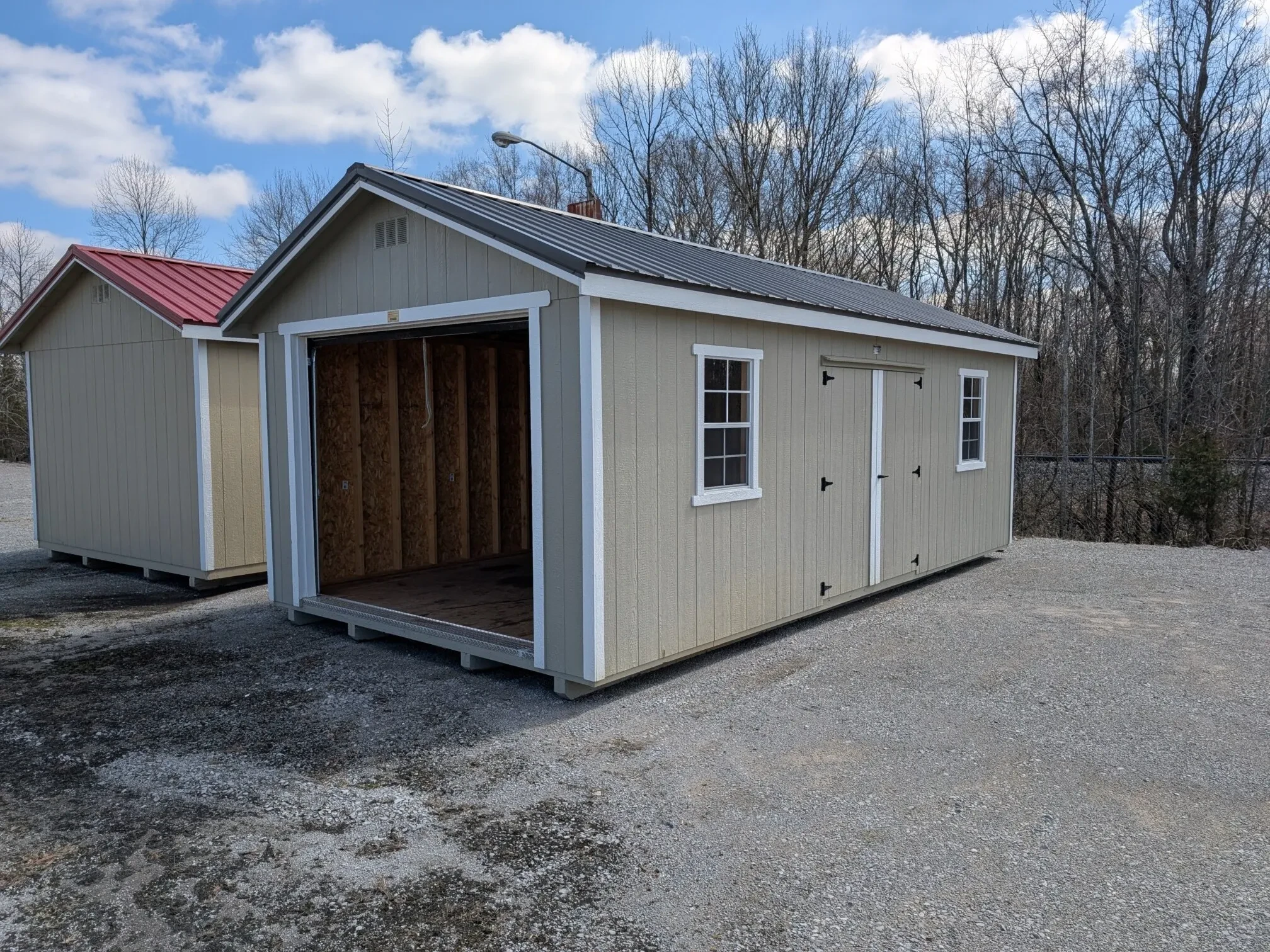 a garage shed with double doors, windows, and the garage door open all the way