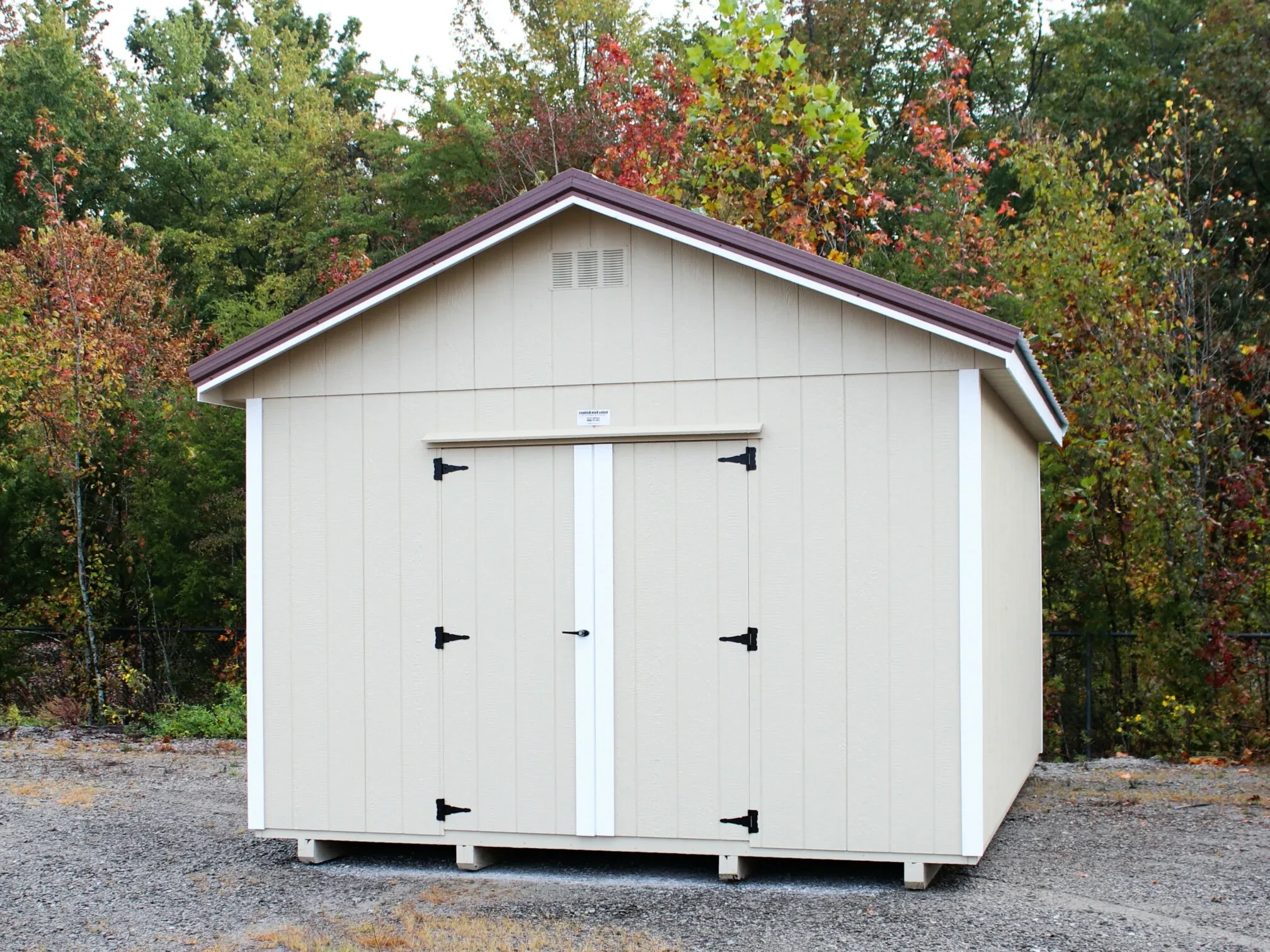 a premium wood TN shed with stone siding and white trim with double doors on the end