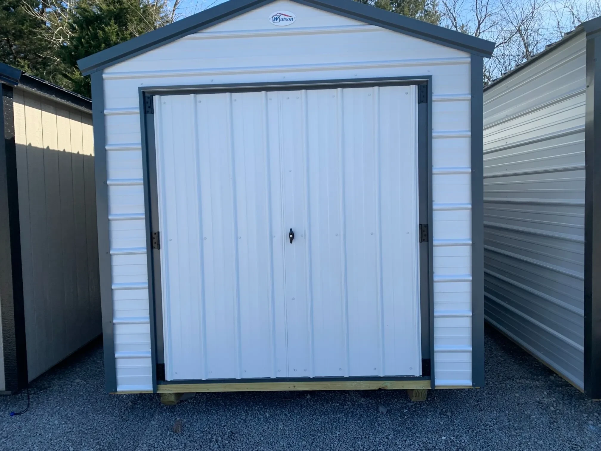 an 8x12 metal shed colored white with gray metal trim