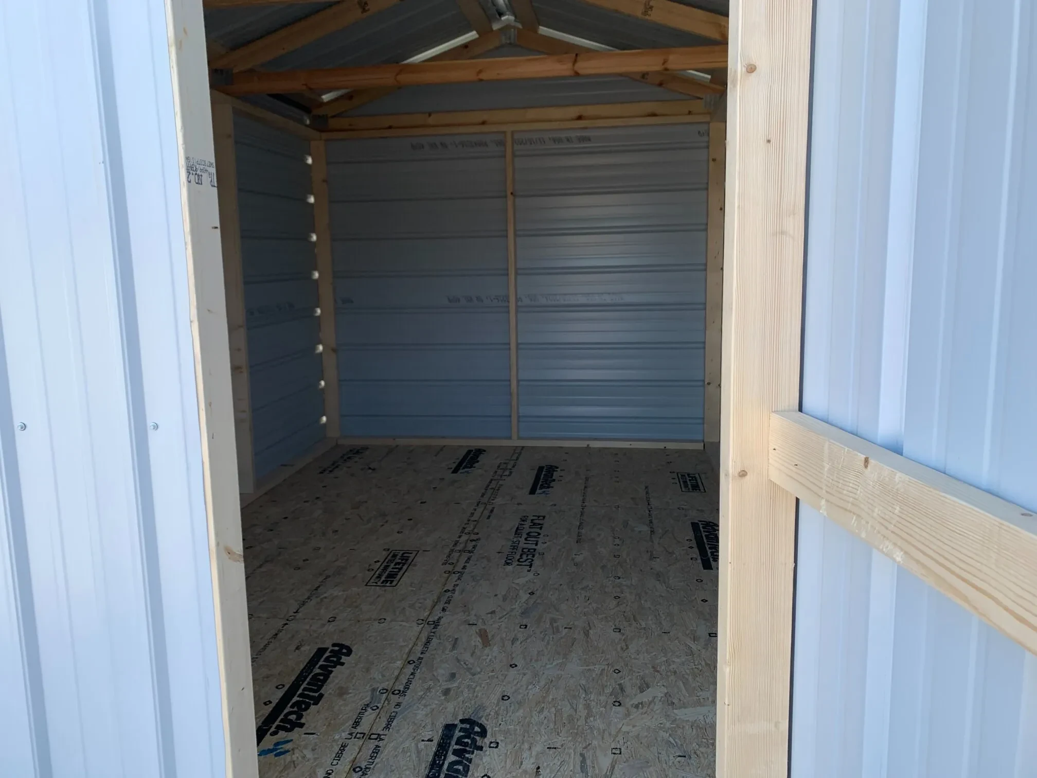 looking inside the door of a white metal shed
