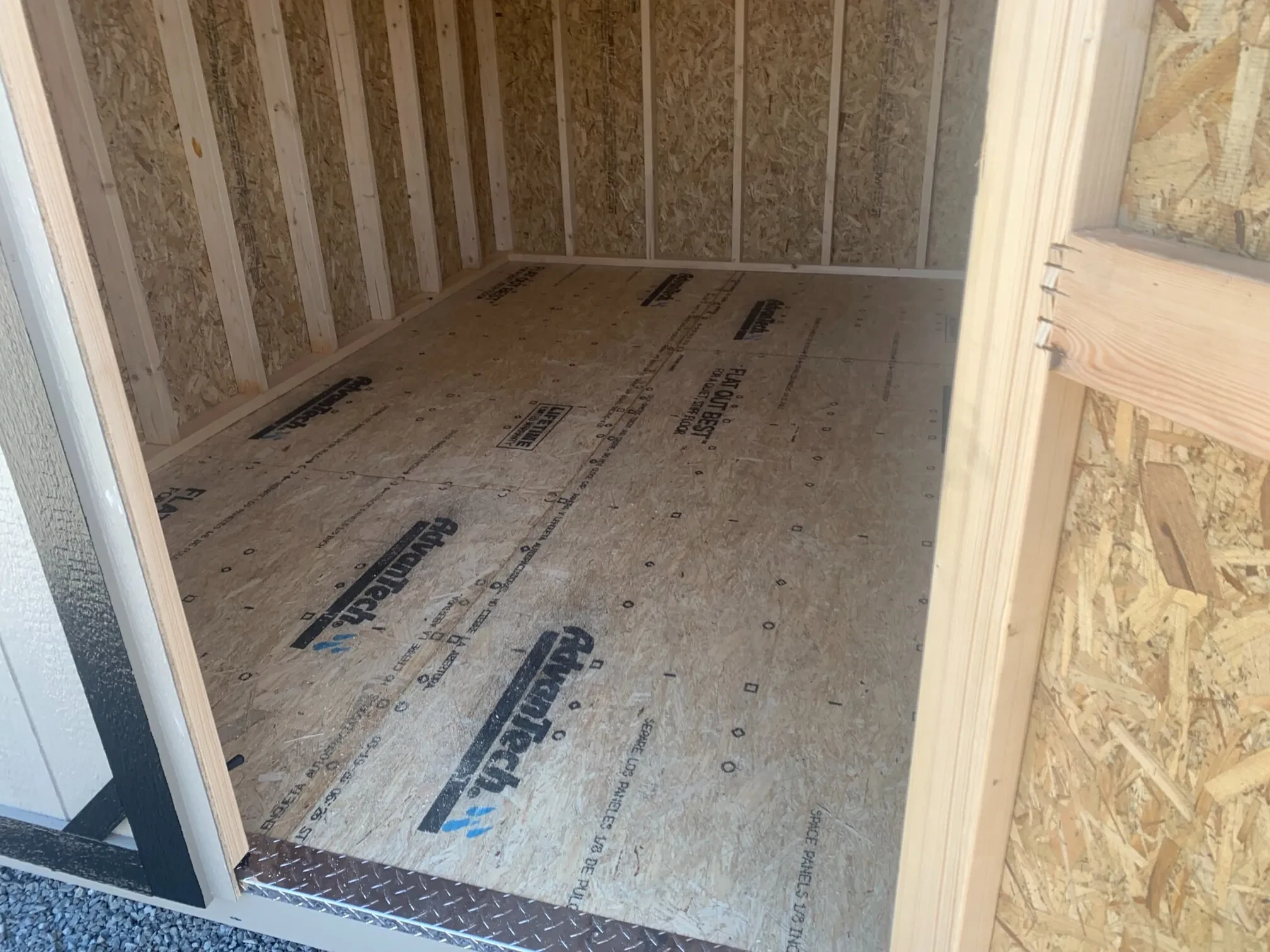 the floor of a wood shed with a door open