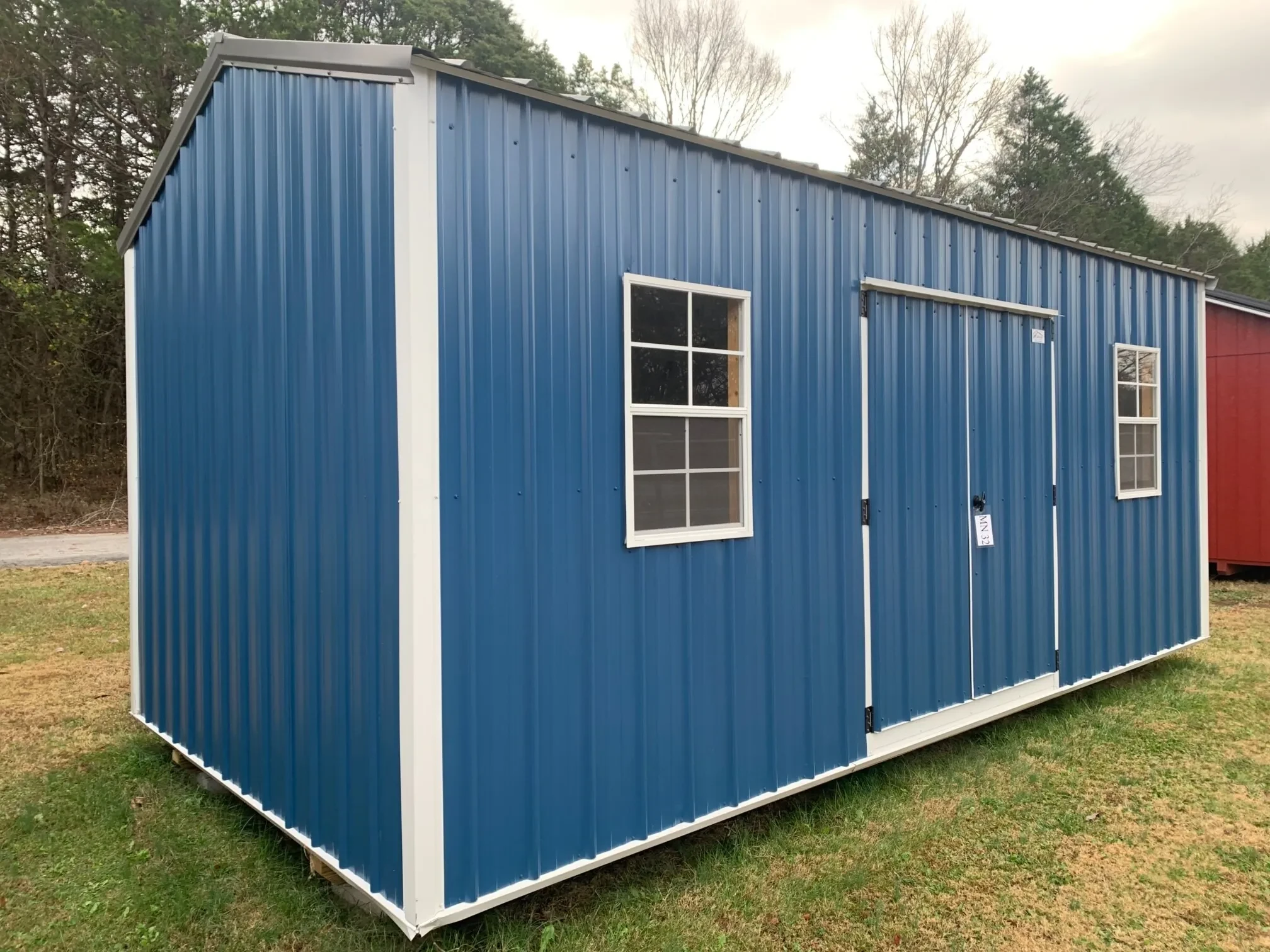 a blue metal garden shed with two windows
