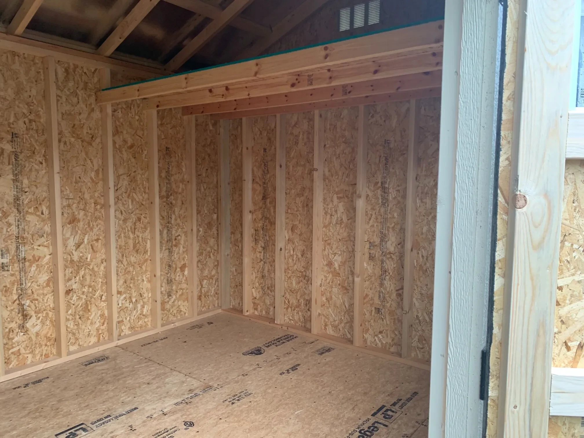inside a wood garden shed with a loft on the right side