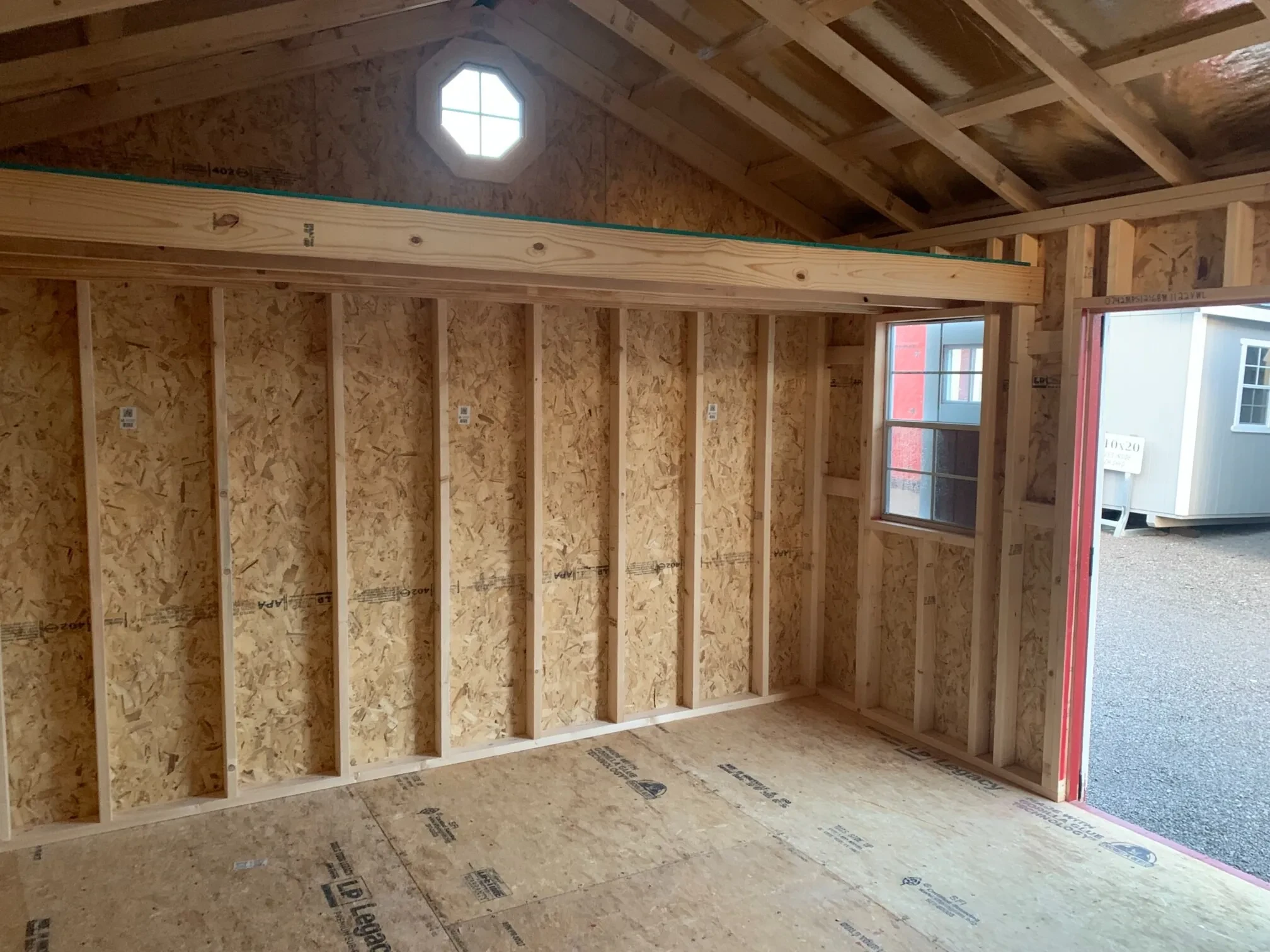 interior of a wood shed with the doors open and a window next to the doors