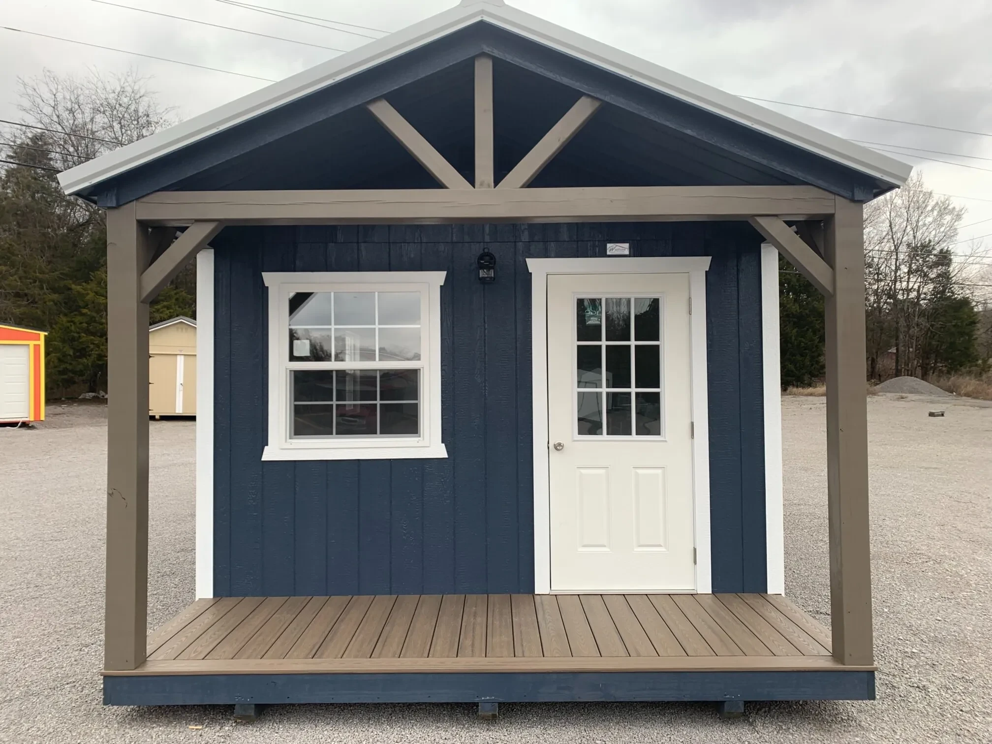 the front of a finished out cabin with a 9-lite walk in door and a vinyl insulated window