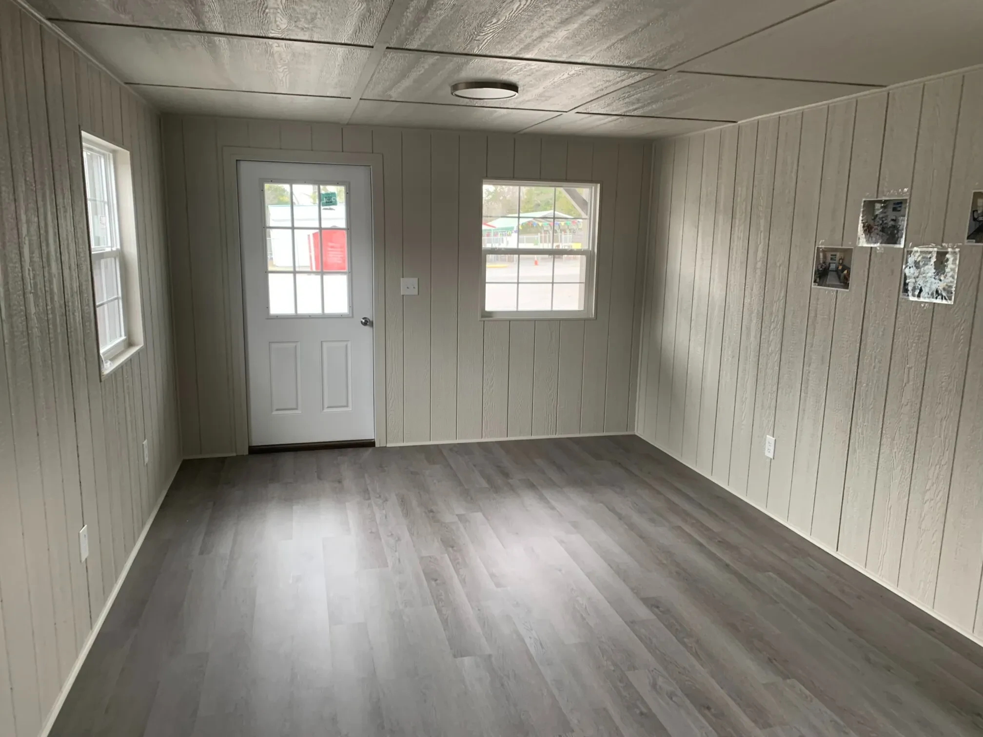 inside a finished out shed showing the 9-lite walk in door and vinyl insulated windows