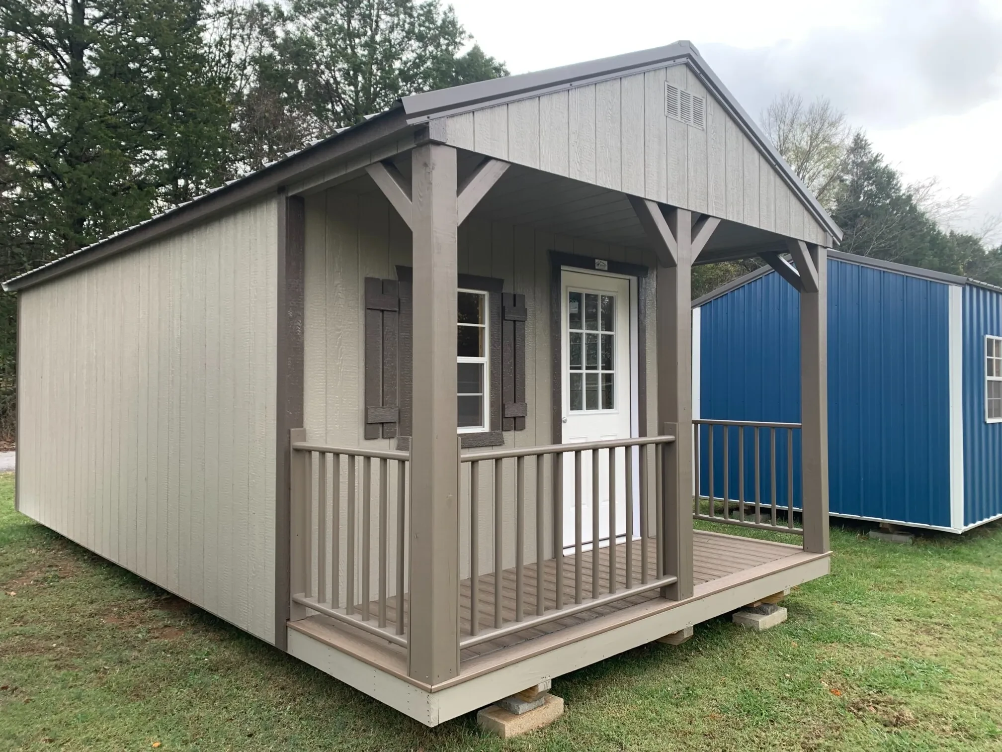 a wood cabin with a walk-in door, a window, and a porch