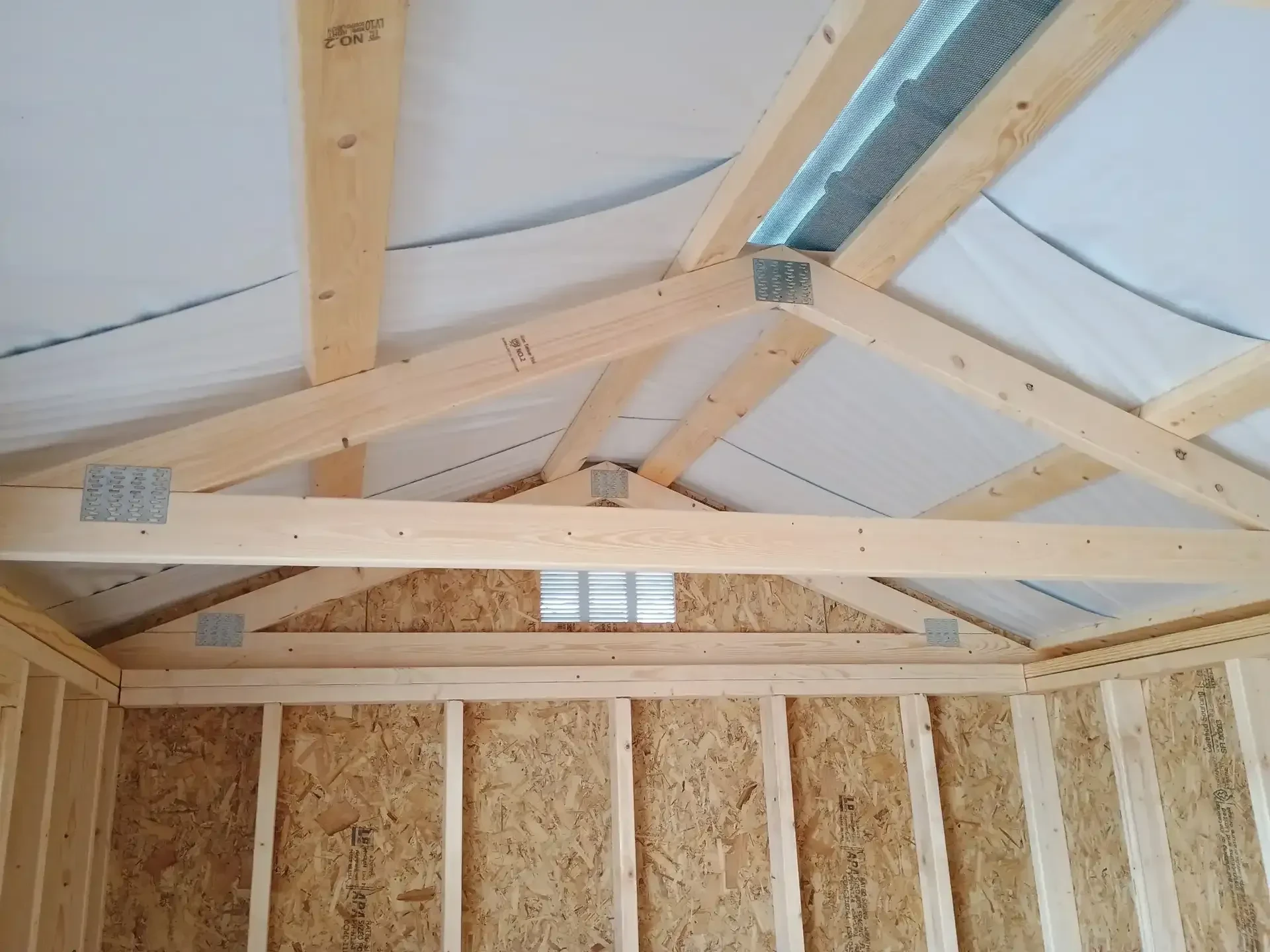 the roof of a wood garden shed showing the foil radiant protection